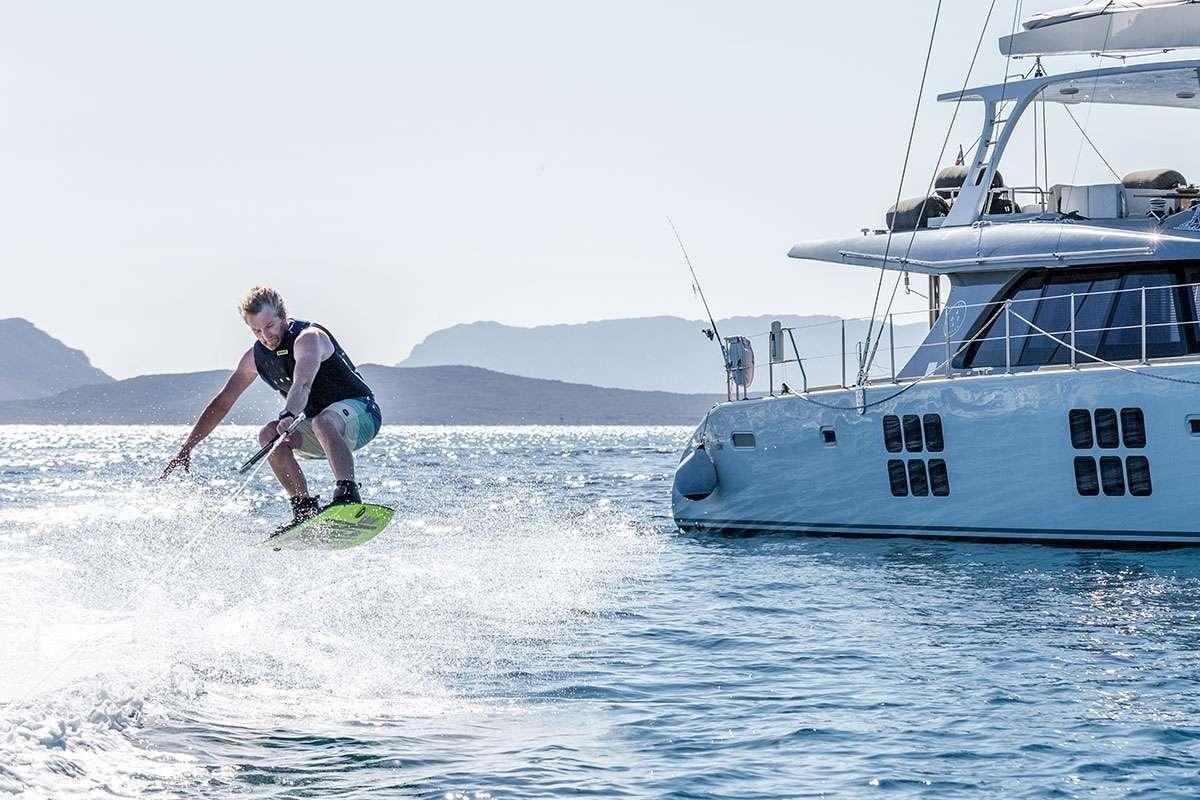 a man surfing in the sea aboard HALCYON Yacht for Charter