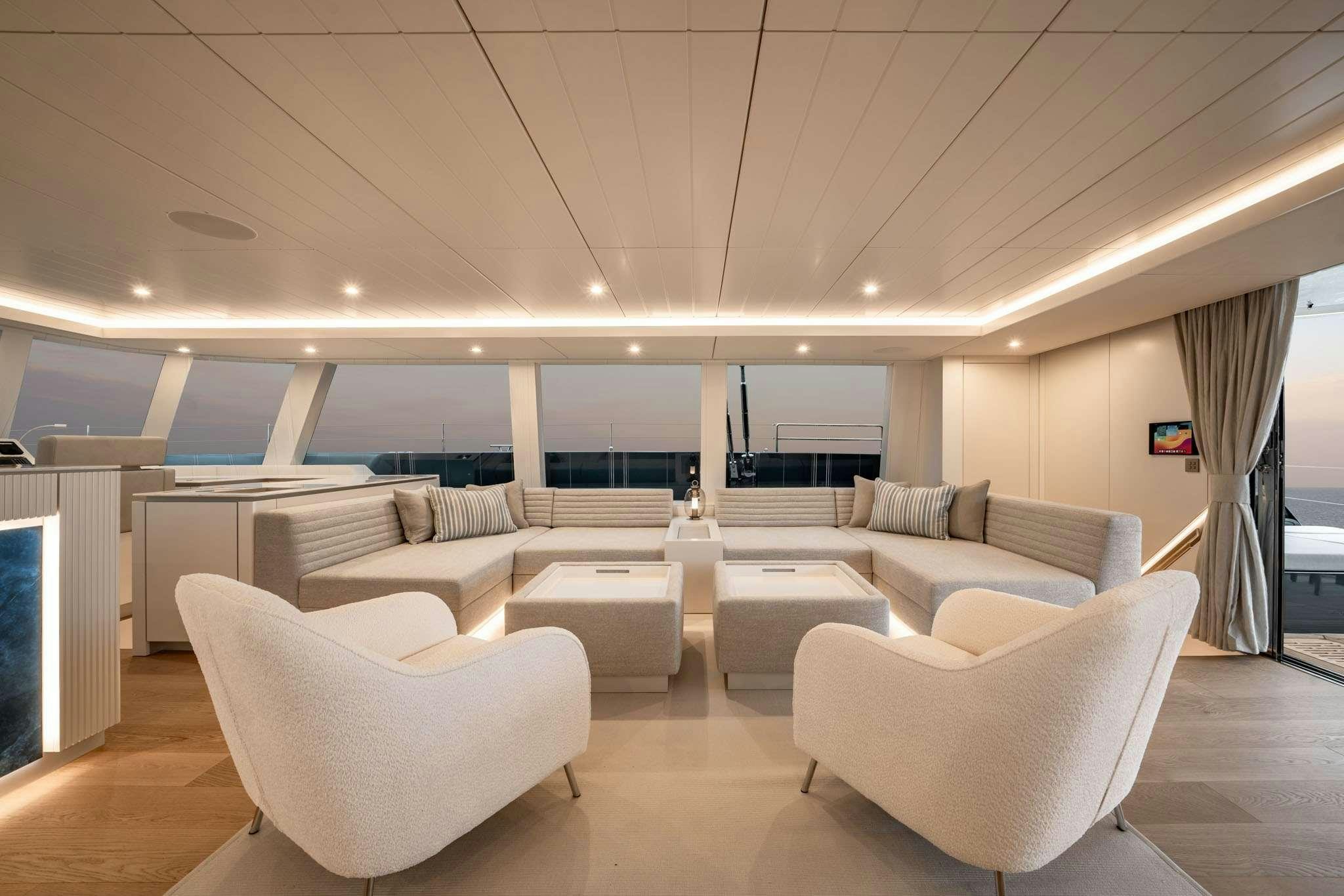 a room with white chairs and a table with a window aboard HALCYON Yacht for Charter
