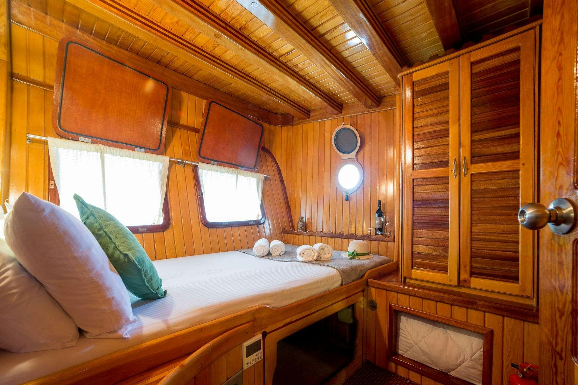 a bed with a wooden headboard aboard SADRI USTA Yacht for Charter