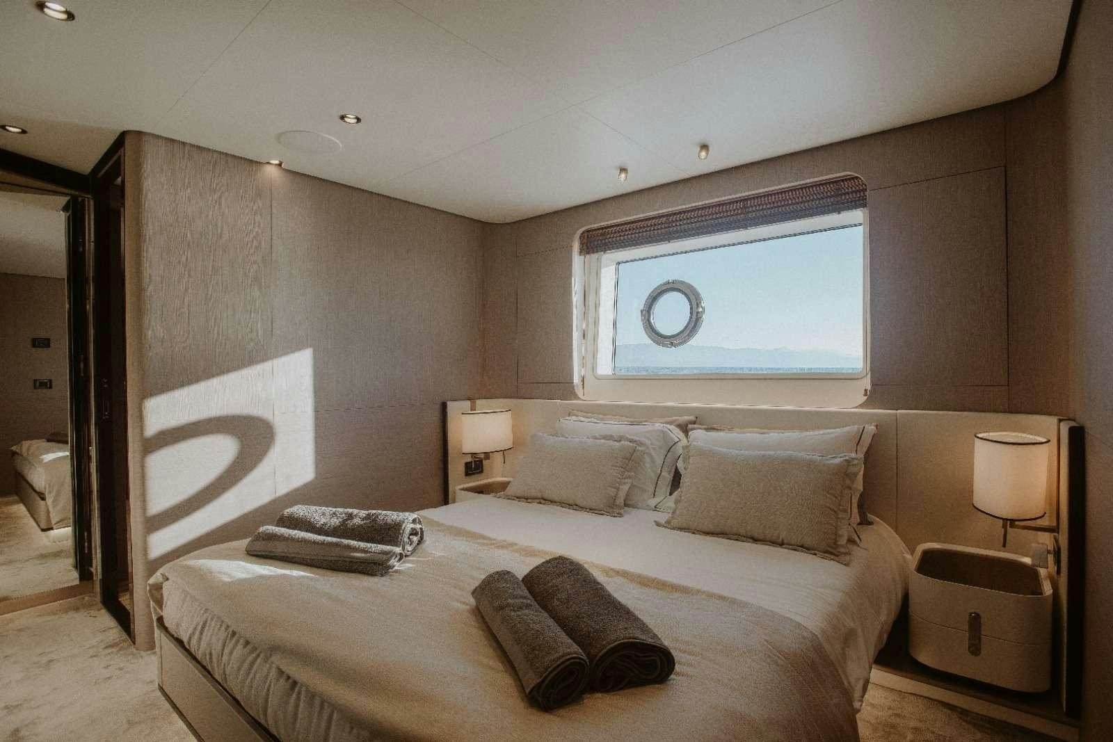 a bed with a white bed spread aboard AGIO Yacht for Charter