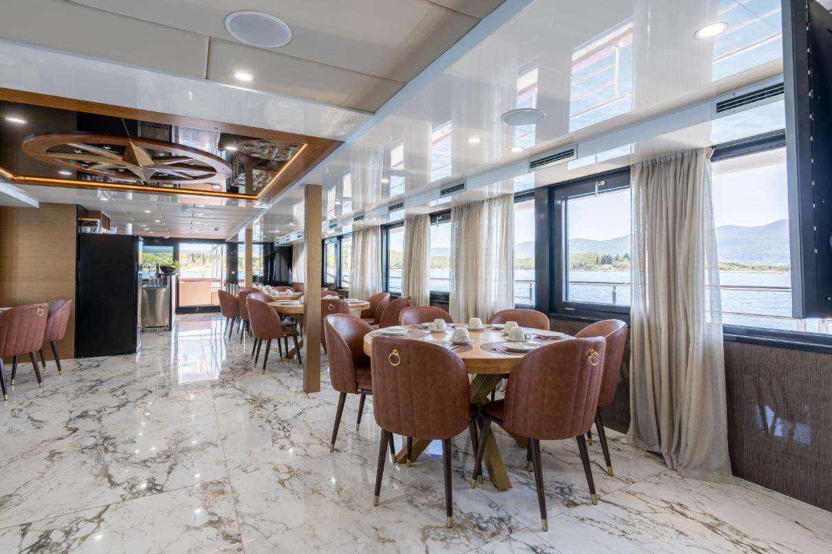 a large room with tables and chairs aboard SYMPHONY Yacht for Charter
