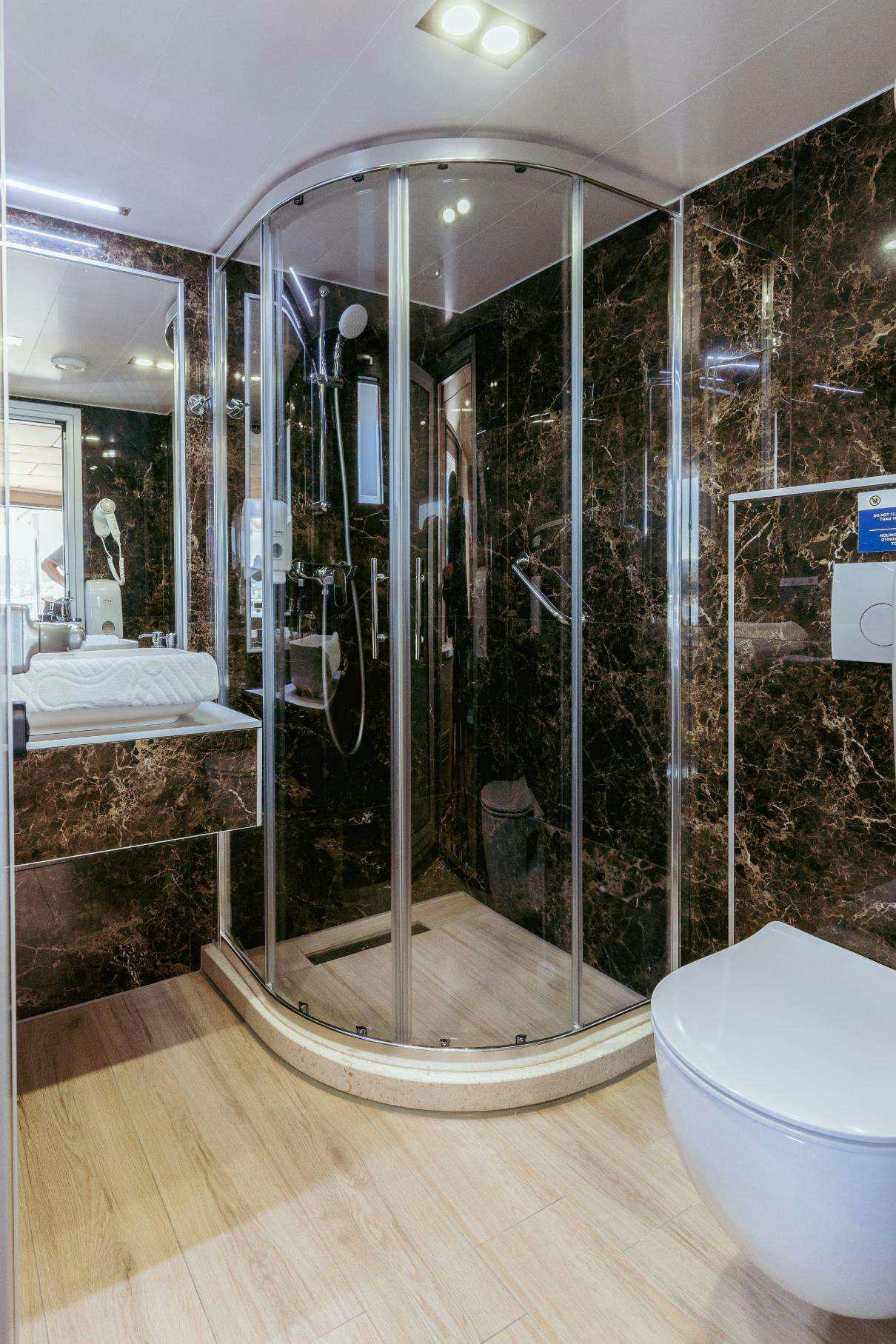 a bathroom with a glass shower aboard SYMPHONY Yacht for Charter