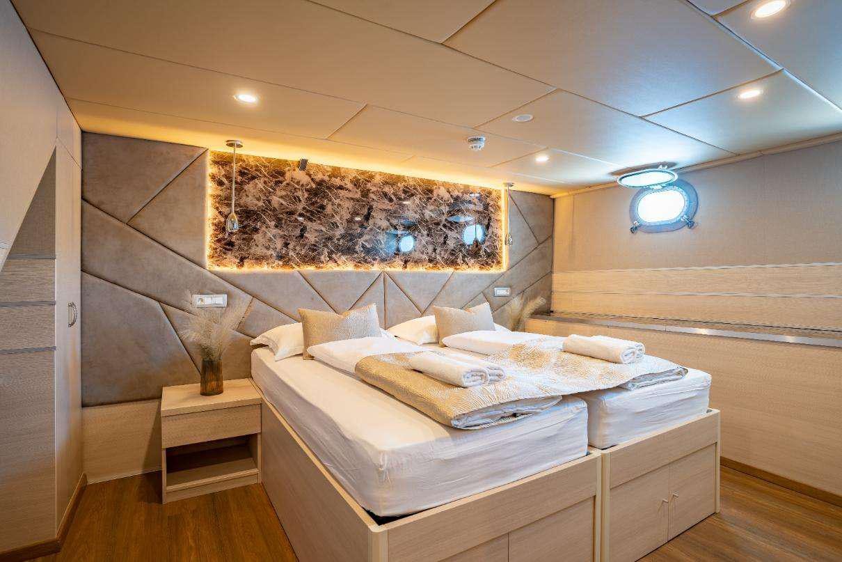 a room with a bed and a wall mounted art on the wall aboard SYMPHONY Yacht for Charter