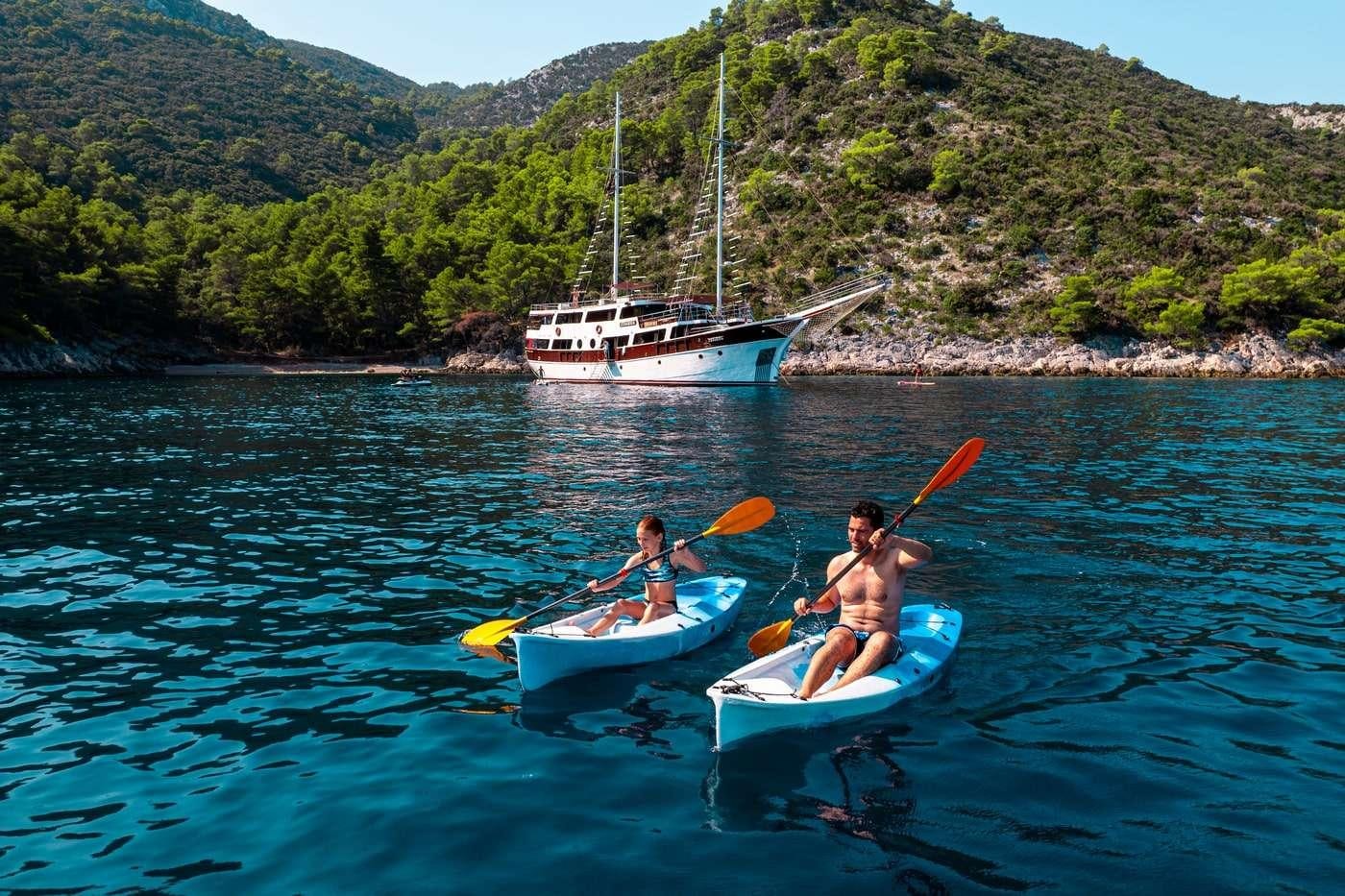 a couple of people in a canoe on a lake aboard CESARICA Yacht for Charter