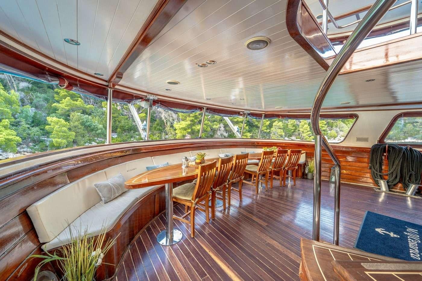 a large room with a couch and a table and chairs aboard CESARICA Yacht for Charter