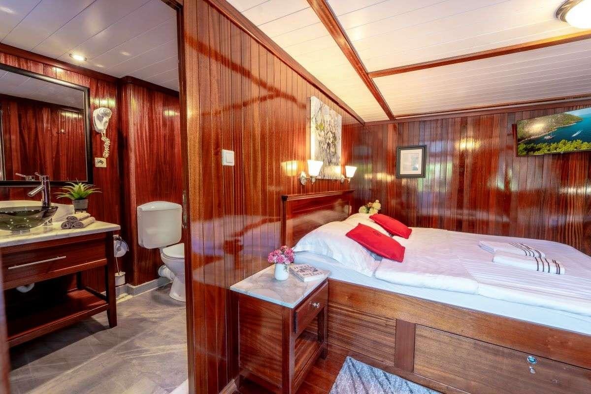 a bedroom with a bed and a desk aboard CESARICA Yacht for Charter