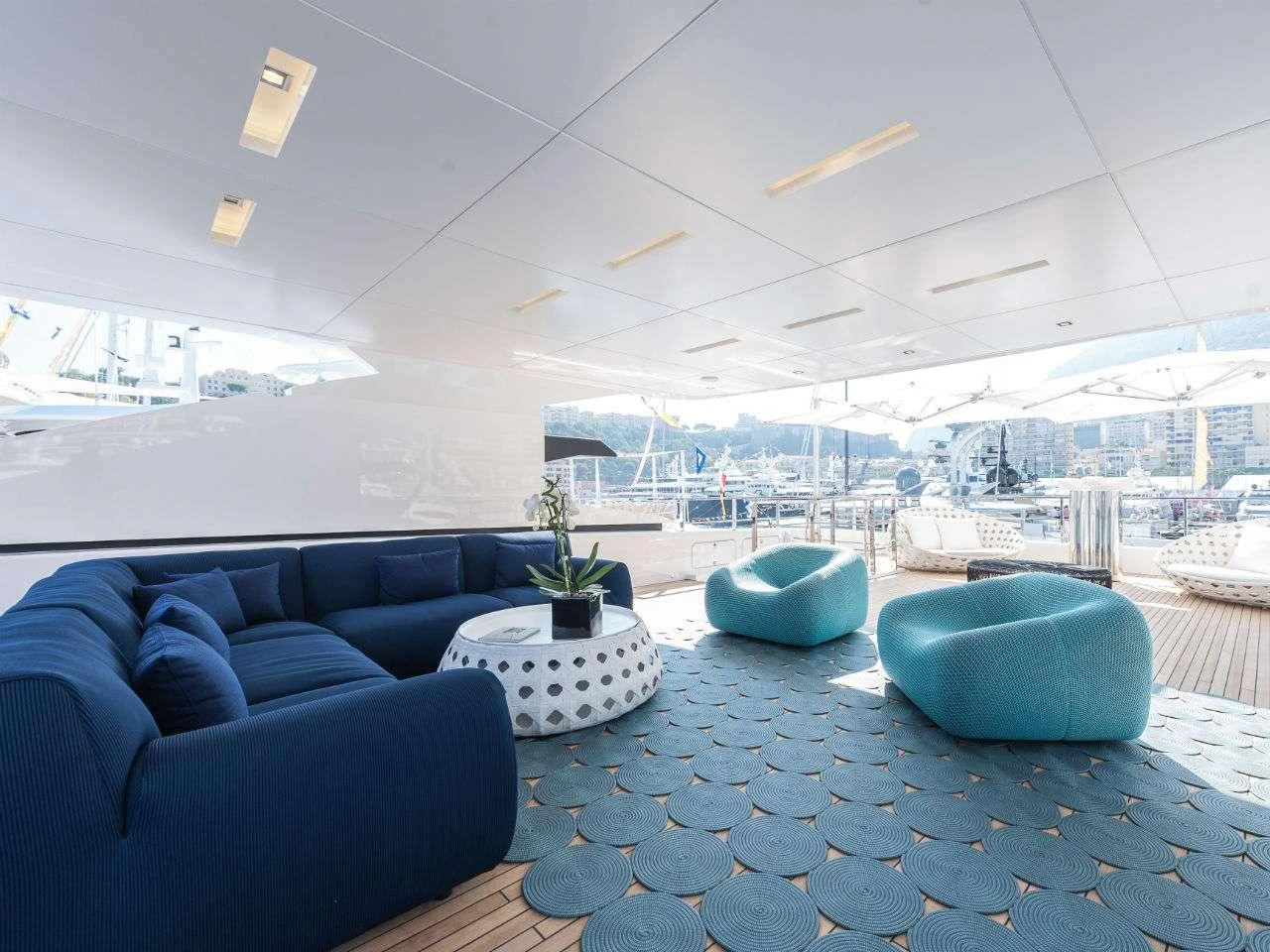 a room with blue couches and a large window aboard AXIOS Yacht for Charter