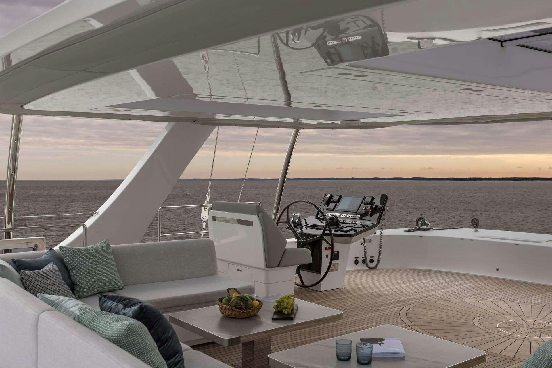 a boat with a table and a couch aboard XMOTION Yacht for Charter