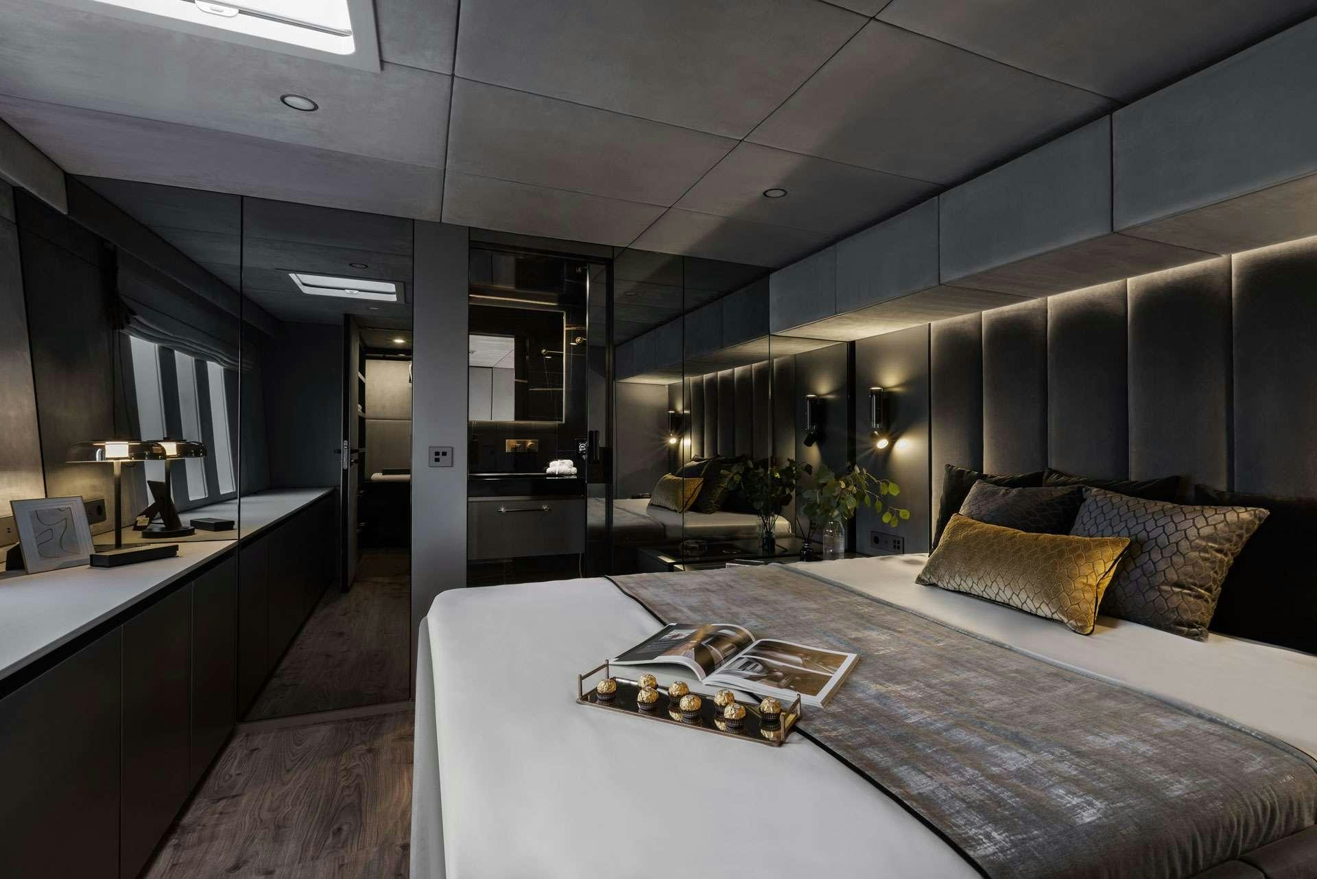 a room with a bed and a desk aboard XMOTION Yacht for Charter