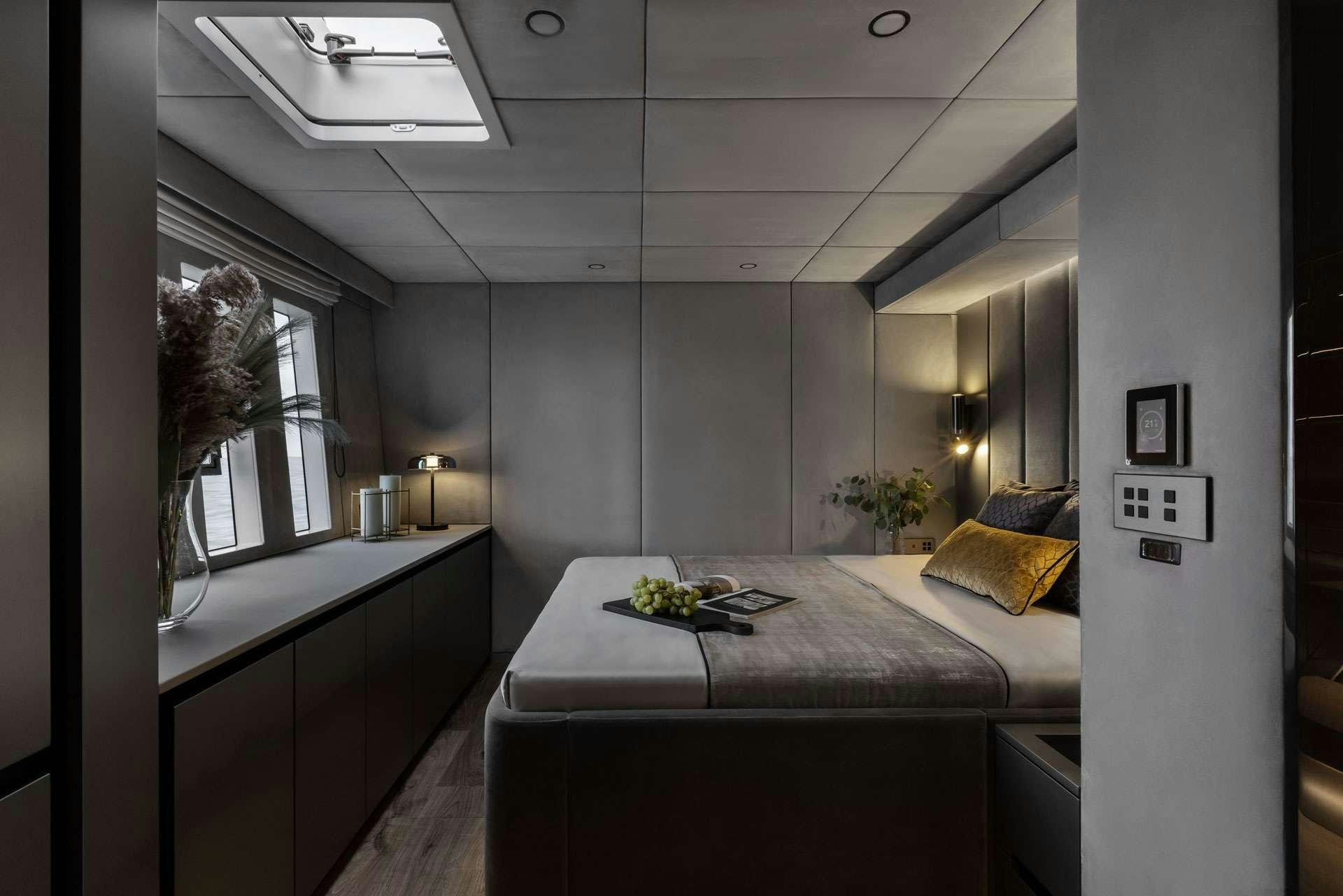a room with a bed and a desk aboard XMOTION Yacht for Charter