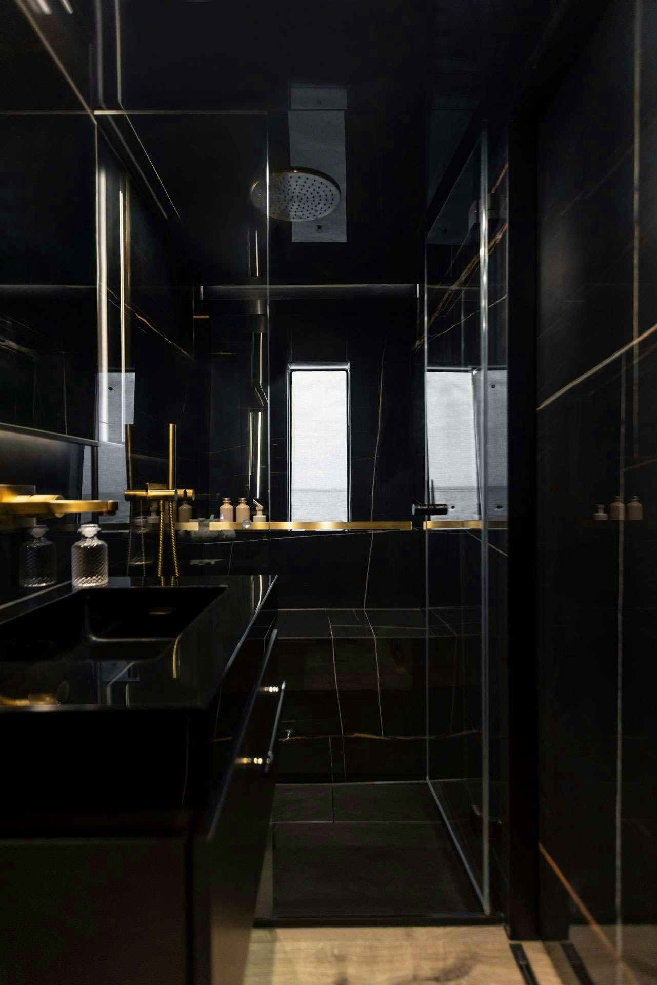 a kitchen with black cabinets aboard XMOTION Yacht for Charter