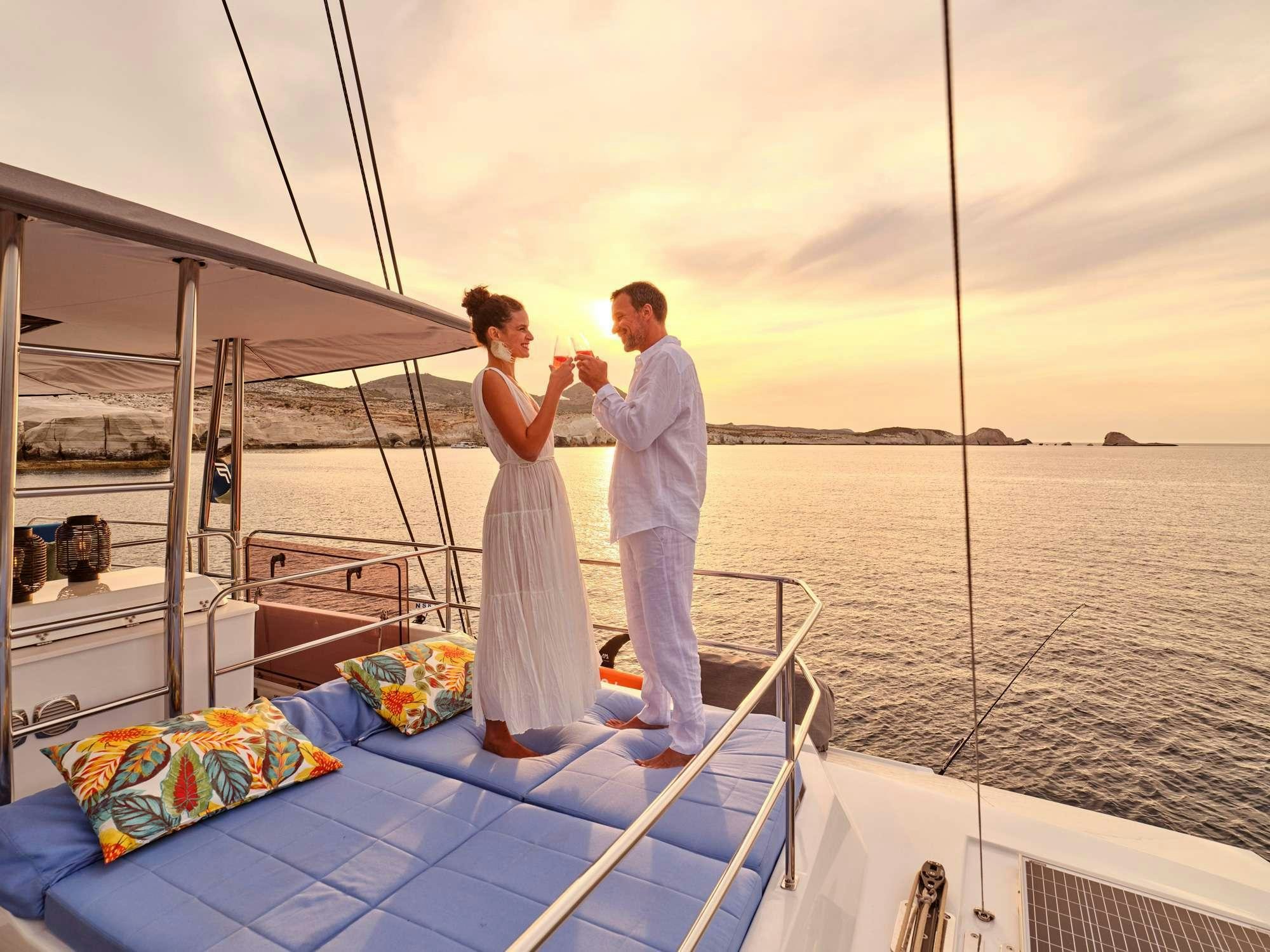 a man and woman standing on a boat with a blanket and a blanket aboard JEWEL Yacht for Charter