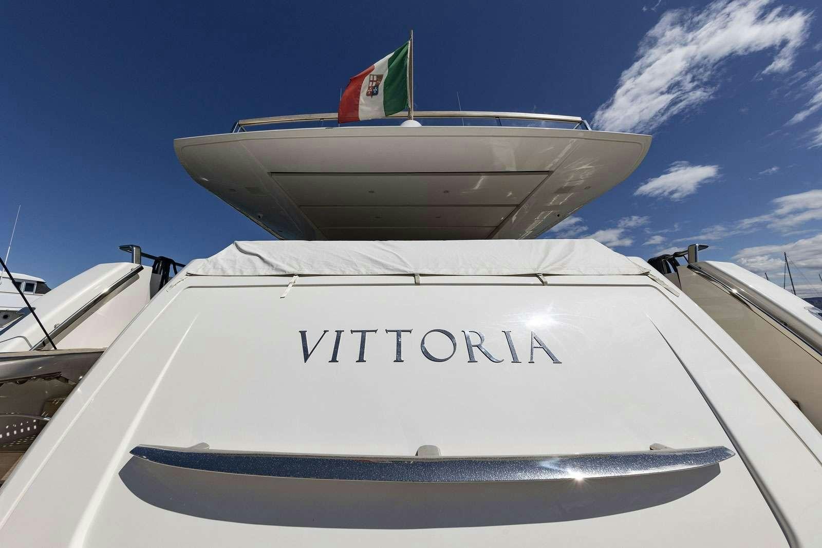 a white boat with a flag on it aboard VITTORIA Yacht for Charter