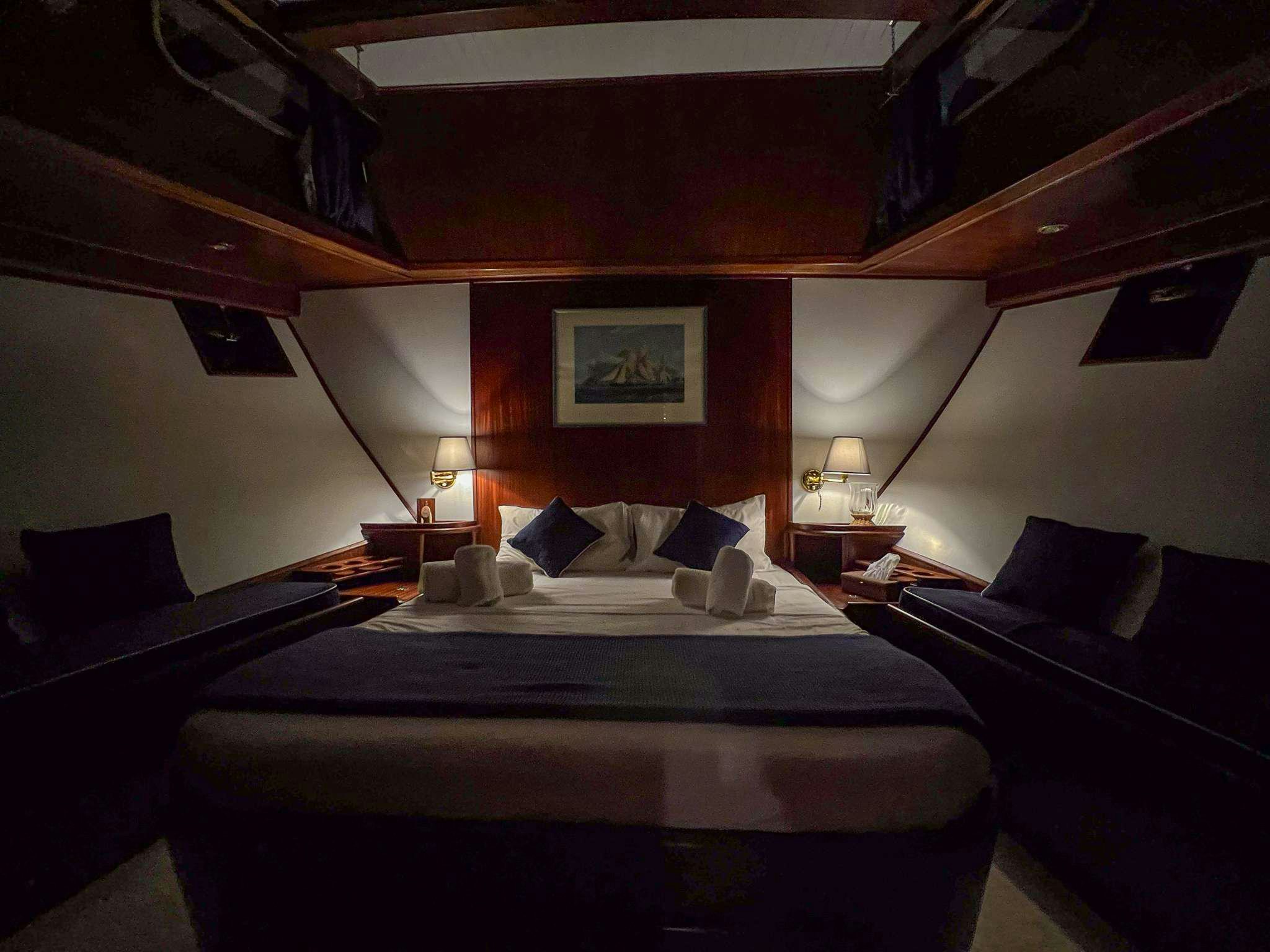 a room with a bed and a couch aboard APHRODITE Yacht for Charter