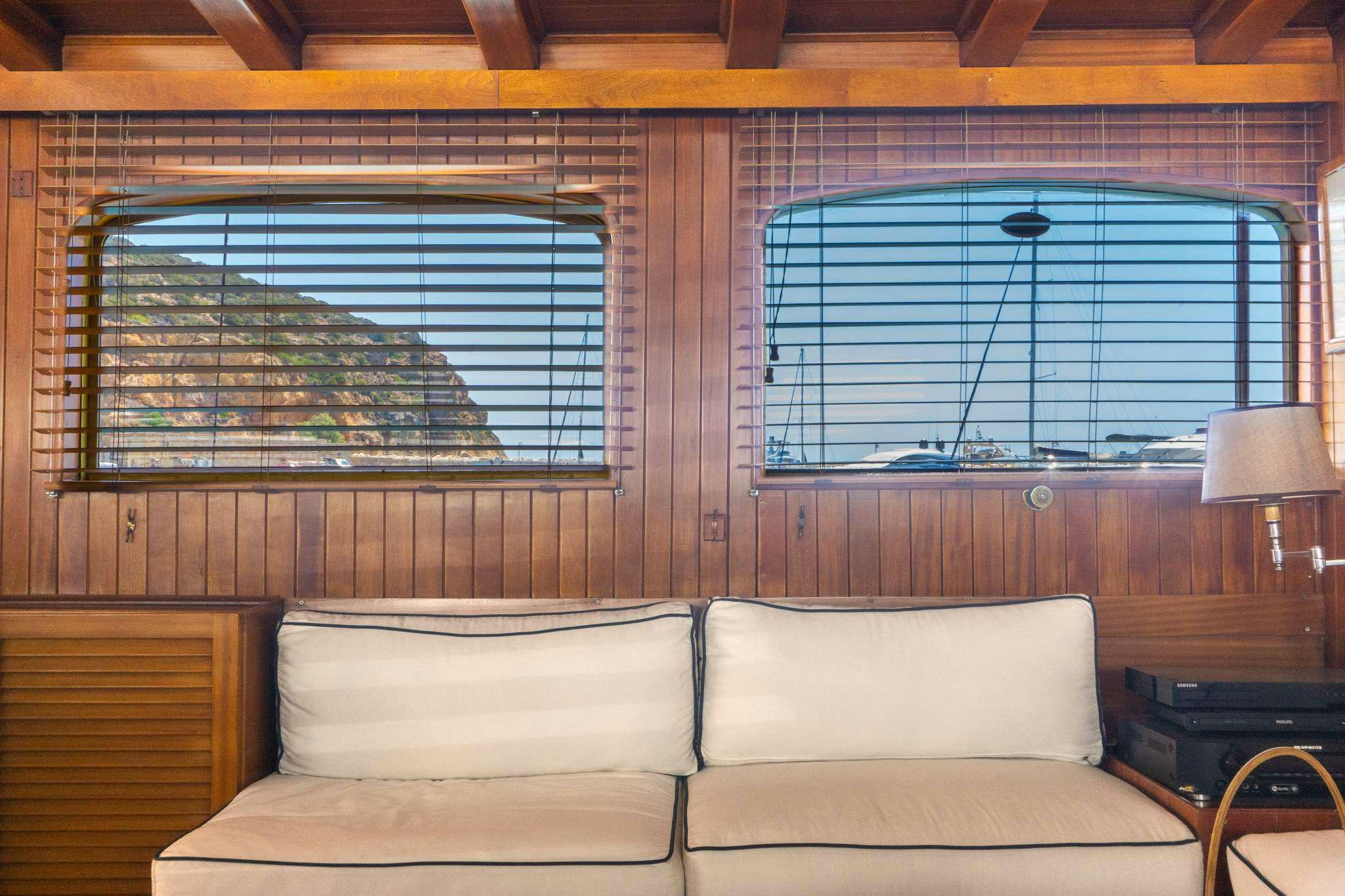 a room with a couch and a window aboard APHRODITE Yacht for Charter