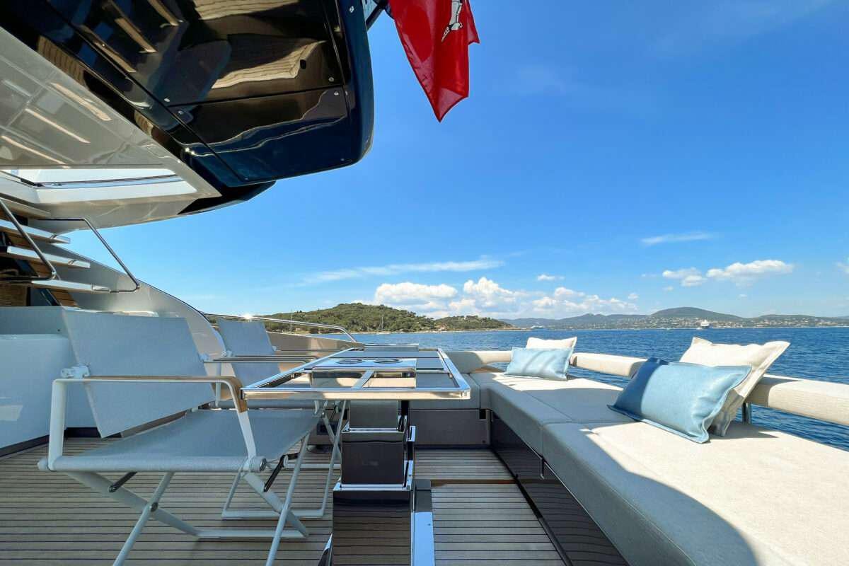 a deck with chairs and a table on it aboard KAR Yacht for Charter