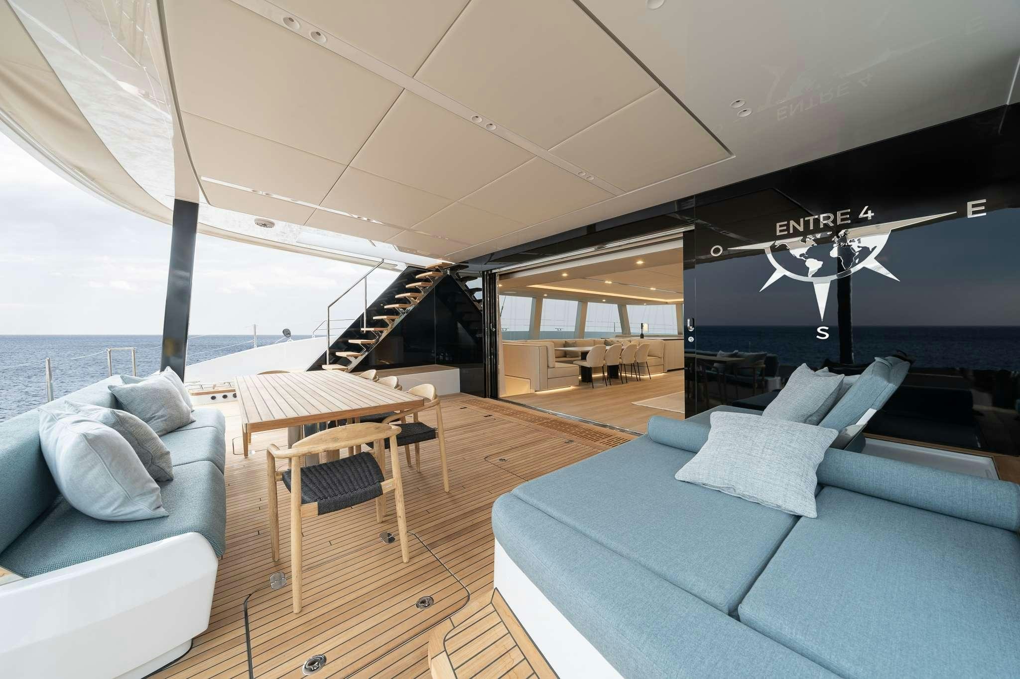 a room with a couch and a table and a large window aboard ENTRE4 Yacht for Charter