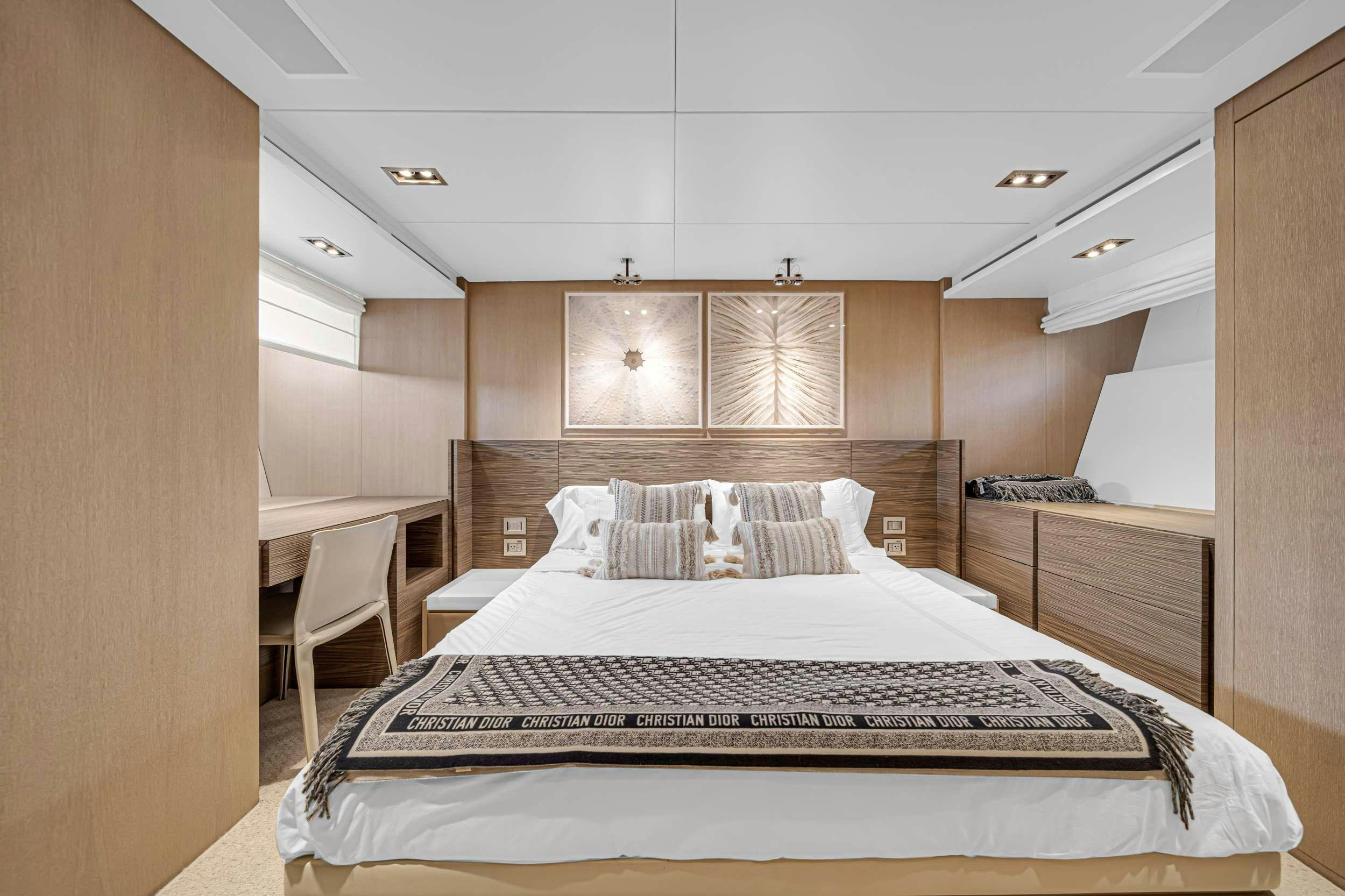 a bedroom with a bed and a chair aboard ASTONISH Yacht for Charter