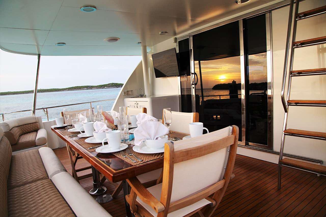 a table with chairs and a view of the ocean aboard CHASER Yacht for Charter