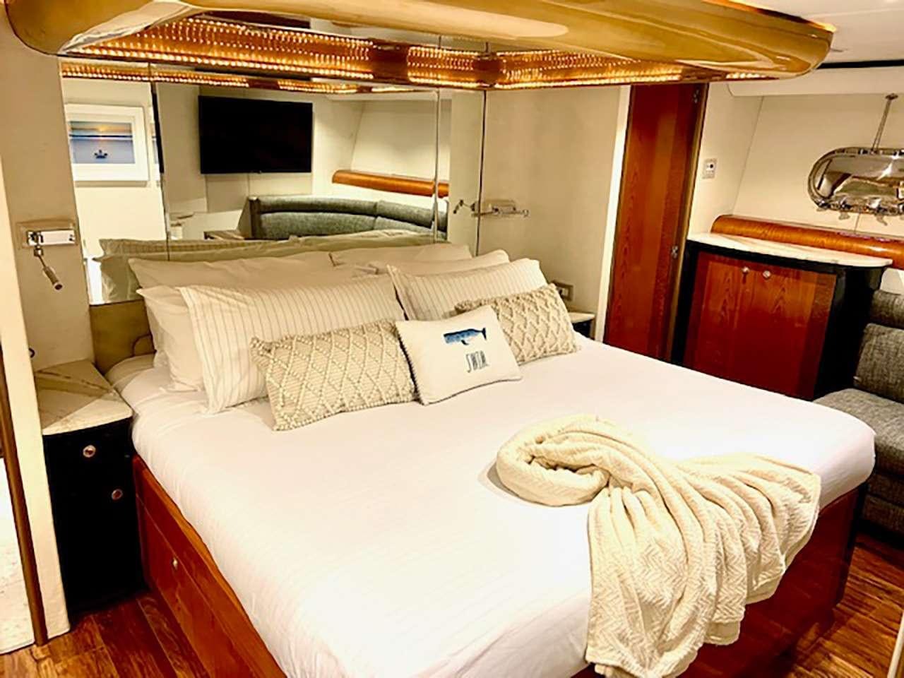 a bed with white sheets and pillows aboard CHASER Yacht for Charter