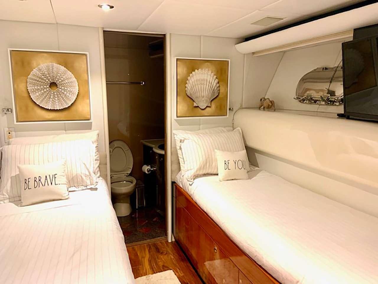 a bedroom with a bed and a television aboard CHASER Yacht for Charter