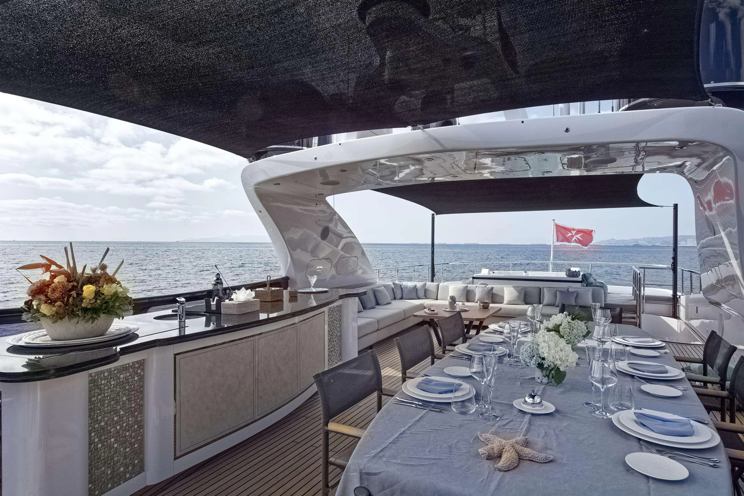a large white building with a large balcony over a large body of water aboard PAREAKI II Yacht for Charter