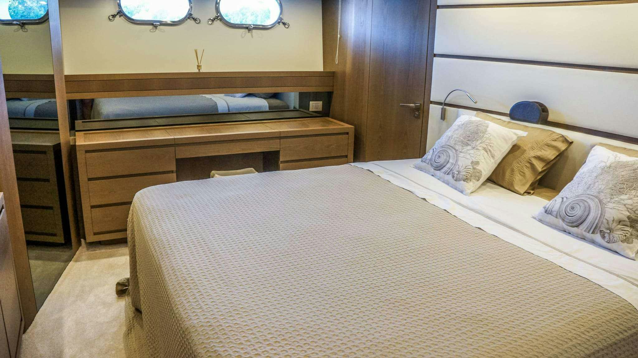 a bed with a white sheet and pillows aboard KUUM Yacht for Charter