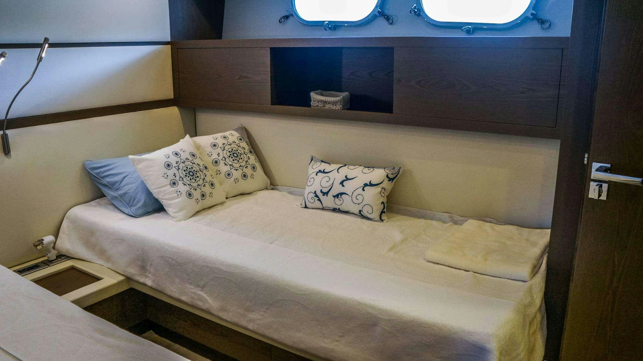 a bed with pillows aboard KUUM Yacht for Charter