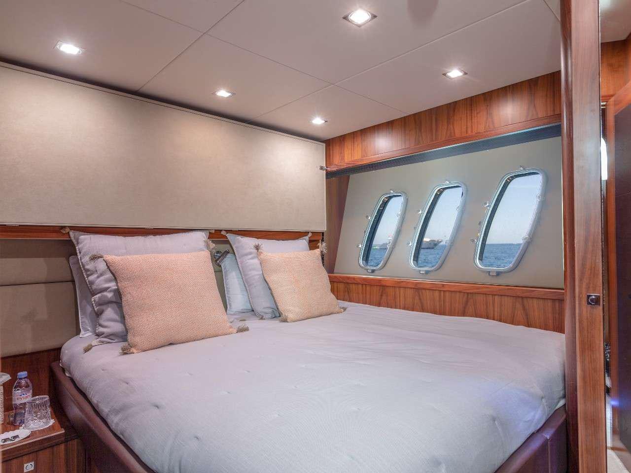 a bed with a white comforter aboard MR SEA Yacht for Charter