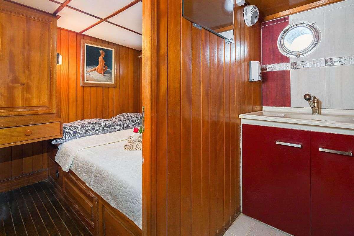 a small bedroom with red cabinets aboard GIDEON Yacht for Charter