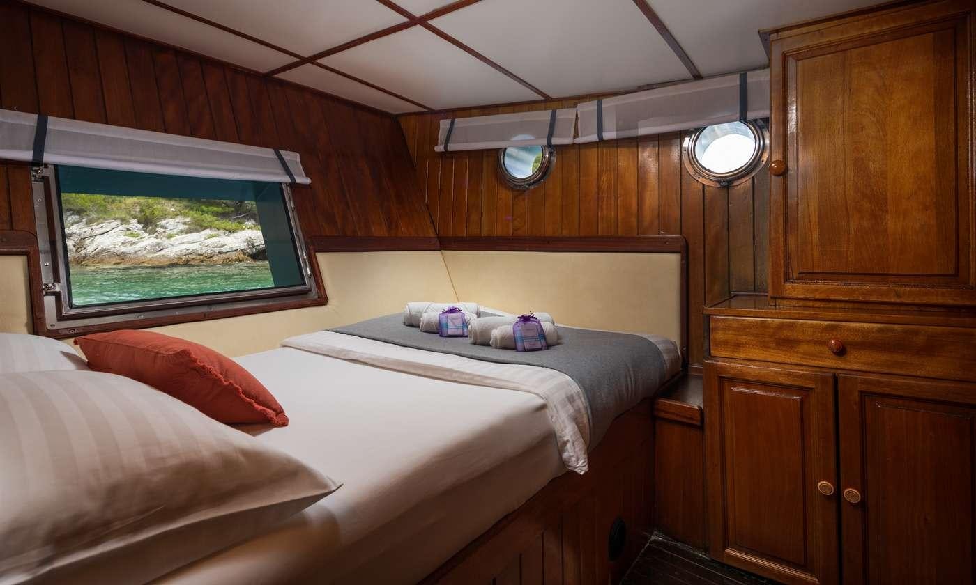 a room with a bed and a window aboard GIDEON Yacht for Charter