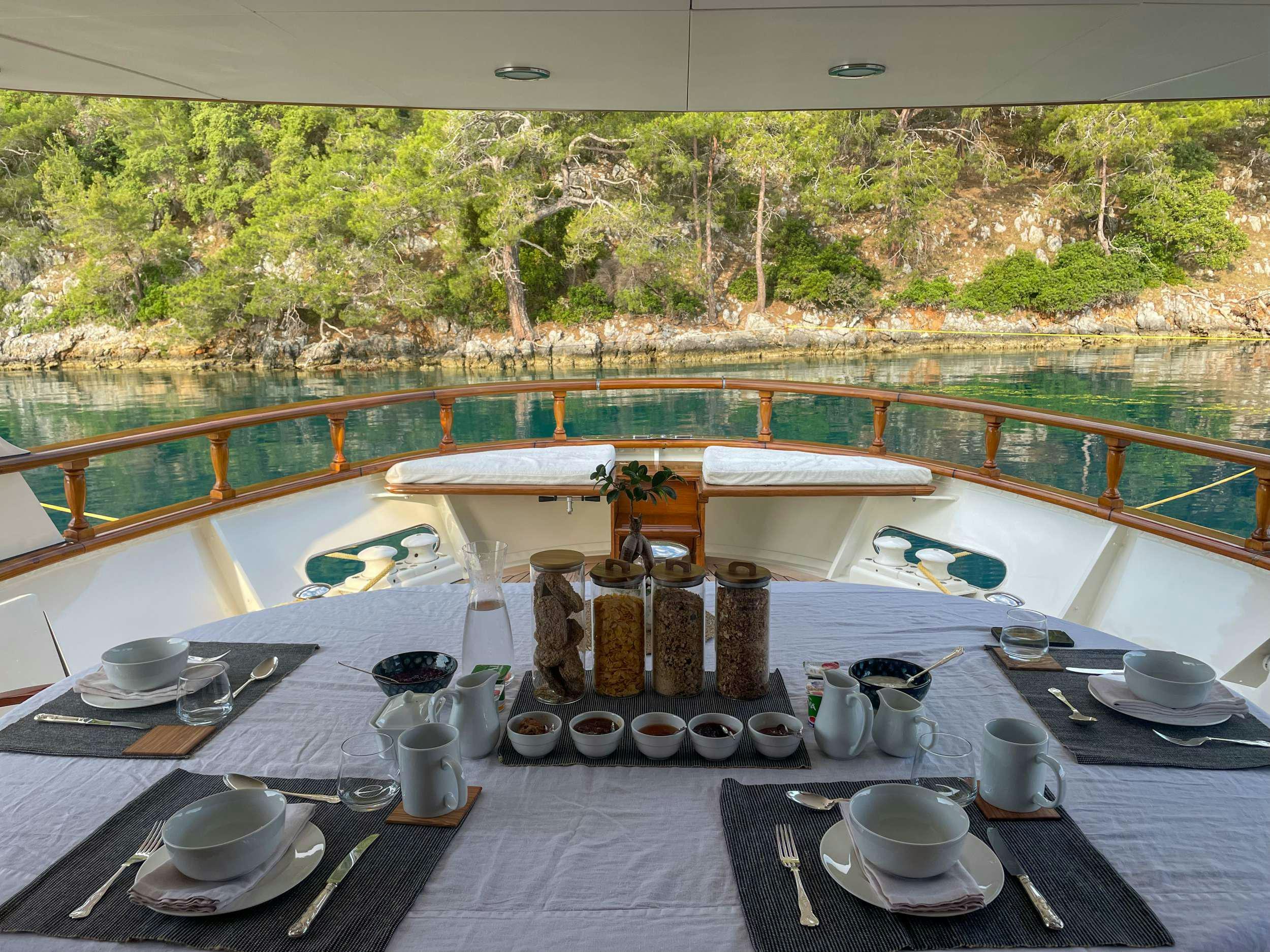 a table with plates and cups on it aboard JURA II Yacht for Charter