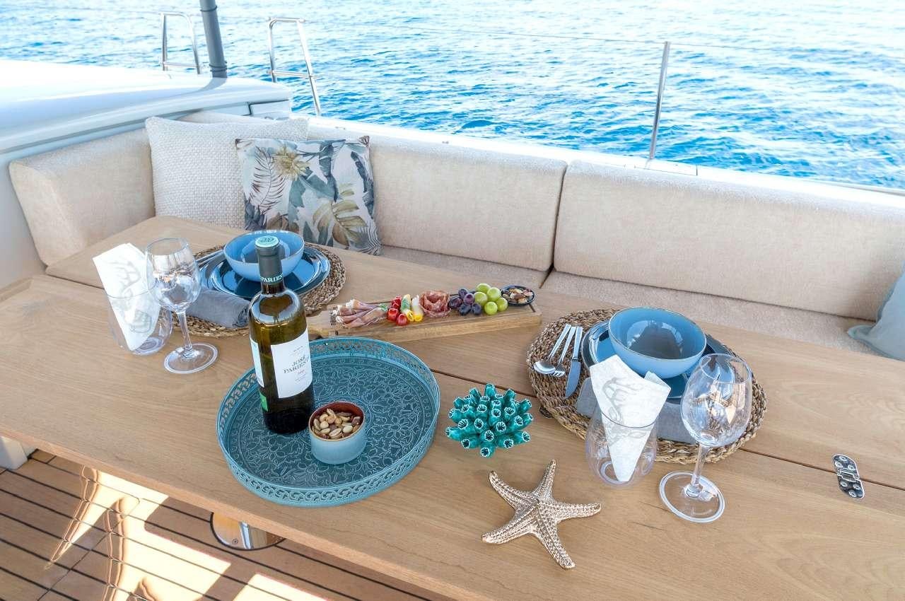 a table with a glass and a bottle of wine on it aboard YUME Yacht for Charter