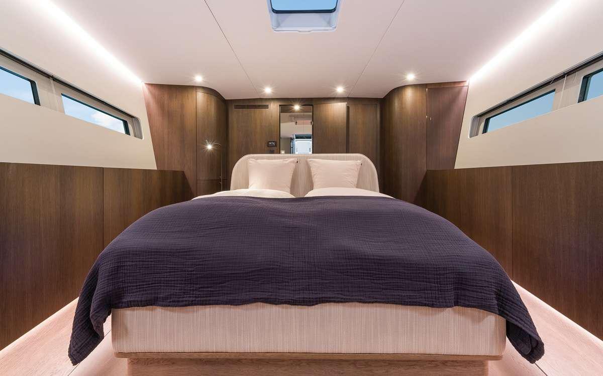 a bed with a black comforter aboard YUME Yacht for Charter