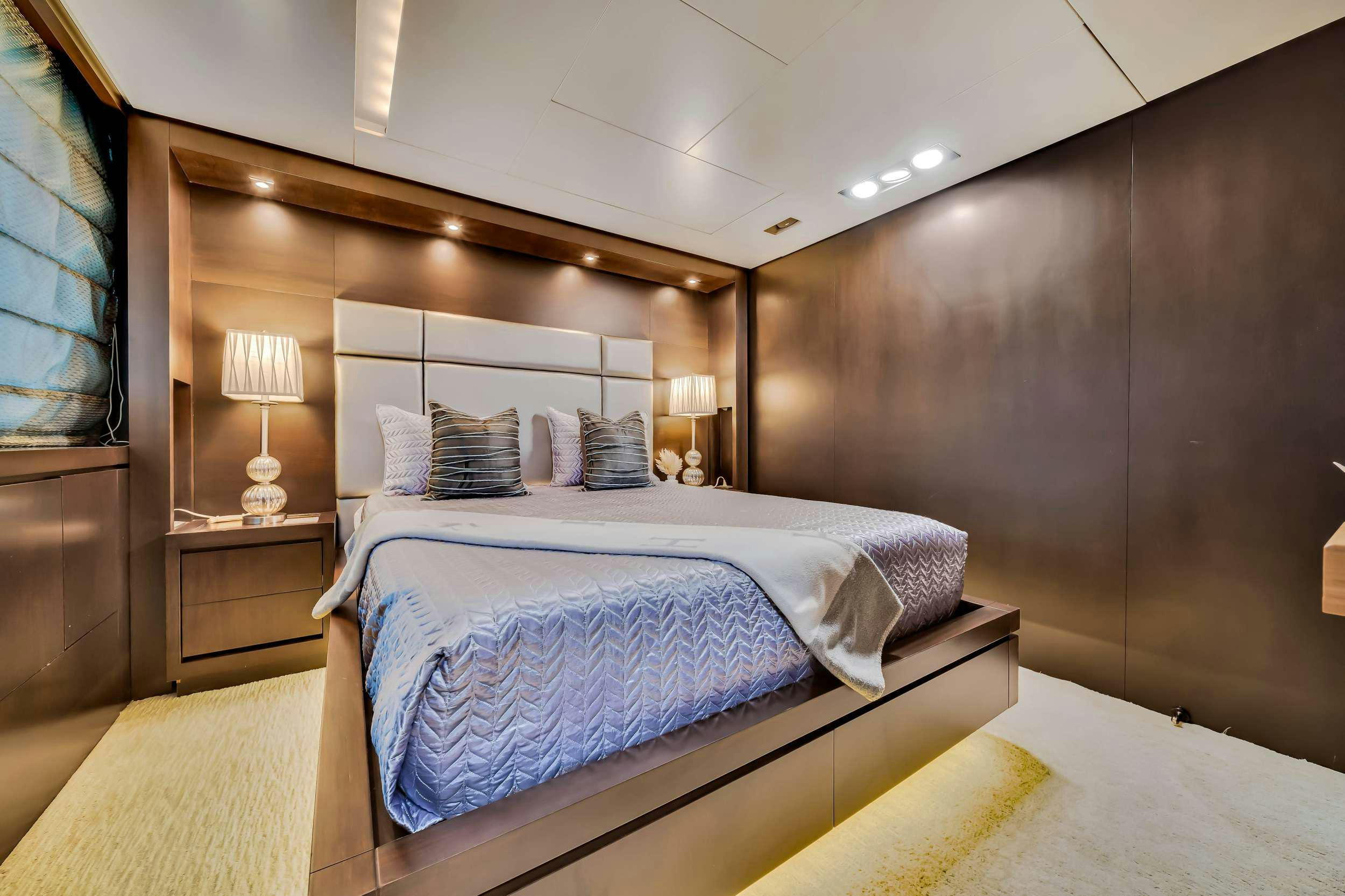 a bedroom with a bed and a lamp aboard RYLAX Yacht for Charter