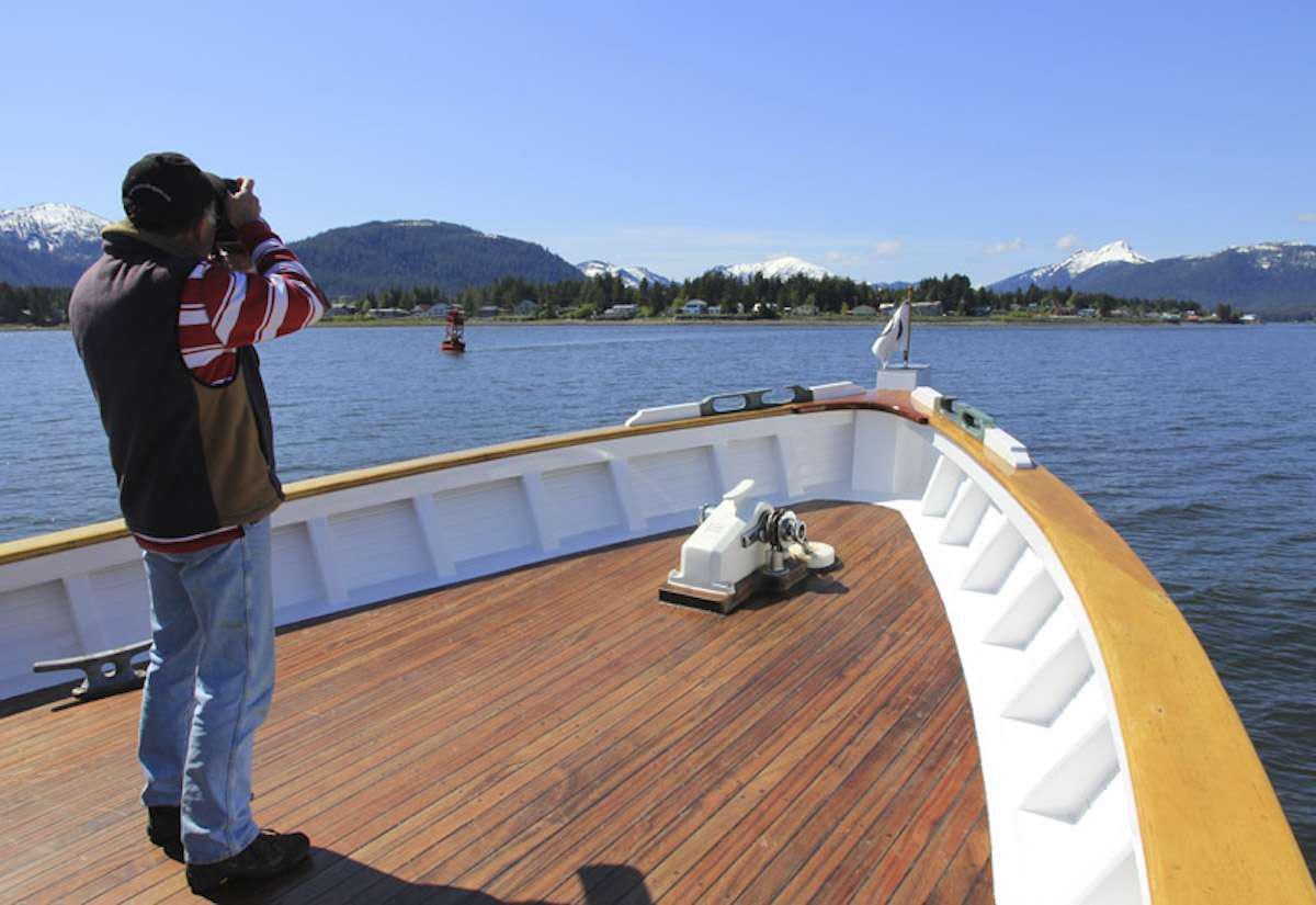 a person taking a picture of a boat on the water aboard DISCOVERY Yacht for Charter