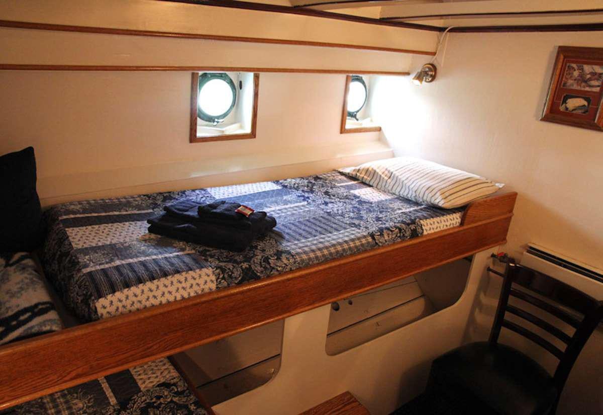 a bed with a mirror above it aboard DISCOVERY Yacht for Charter