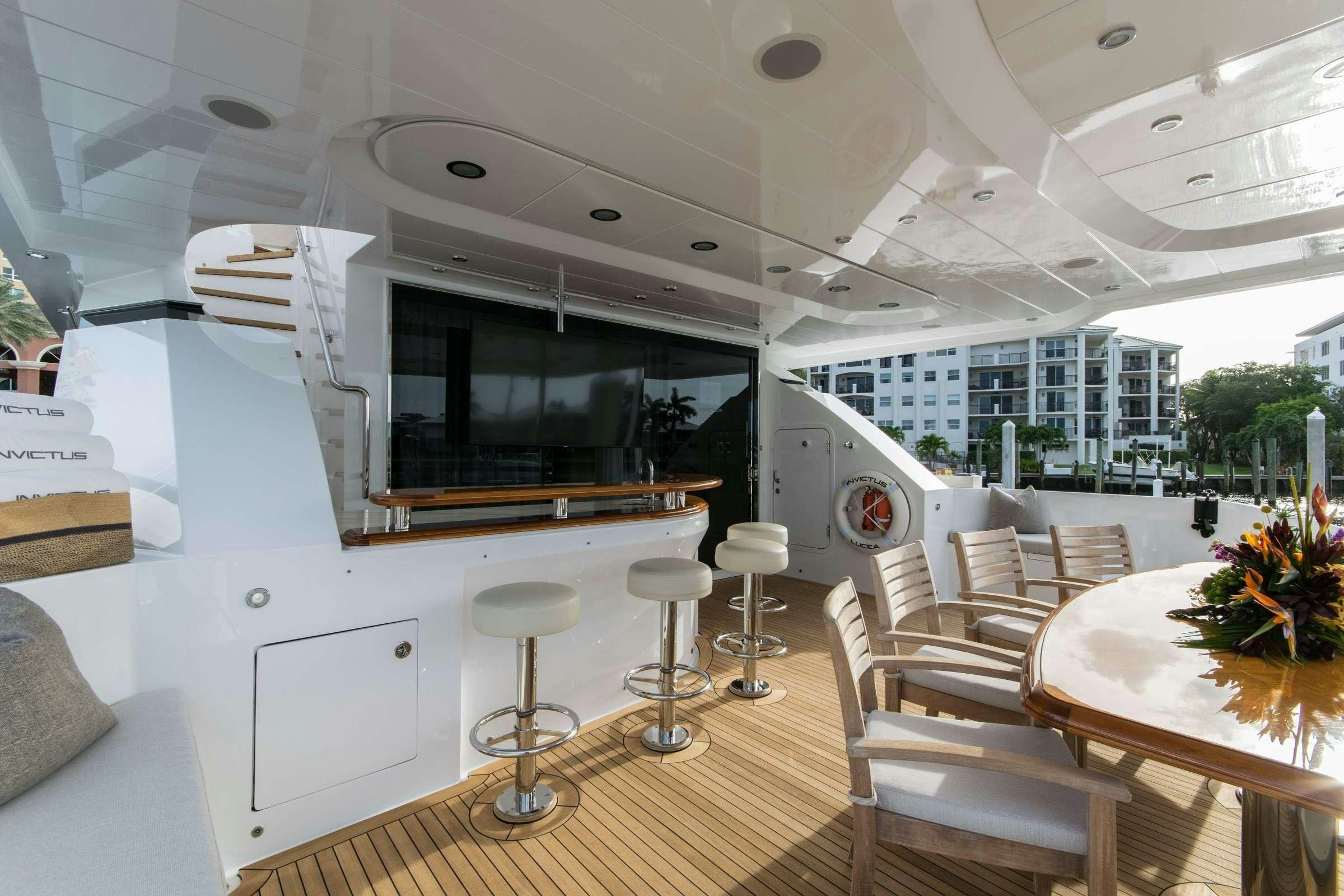 a room with tables chairs and a large window aboard INVICTUS Yacht for Charter