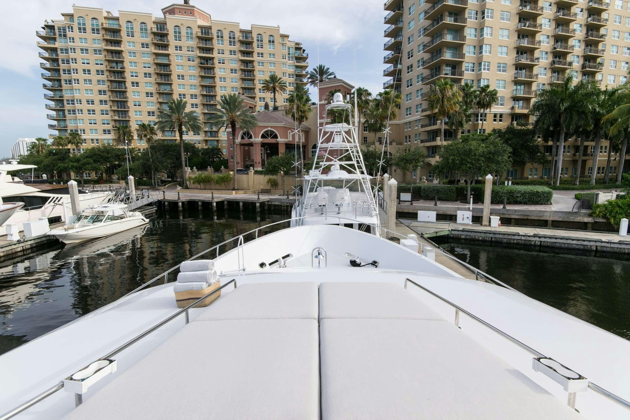 a large white boat in a harbor aboard INVICTUS Yacht for Charter