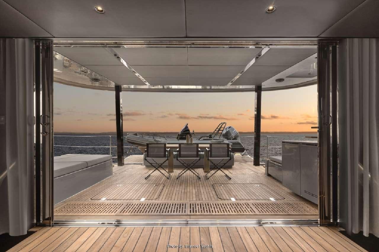 a deck with a table and chairs aboard SHADES OF GREY Yacht for Charter