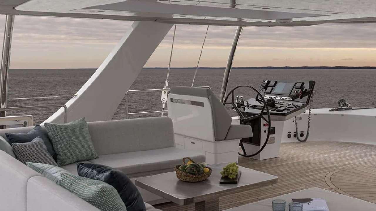a white sofa and a table with a white laptop on it aboard SHADES OF GREY Yacht for Charter