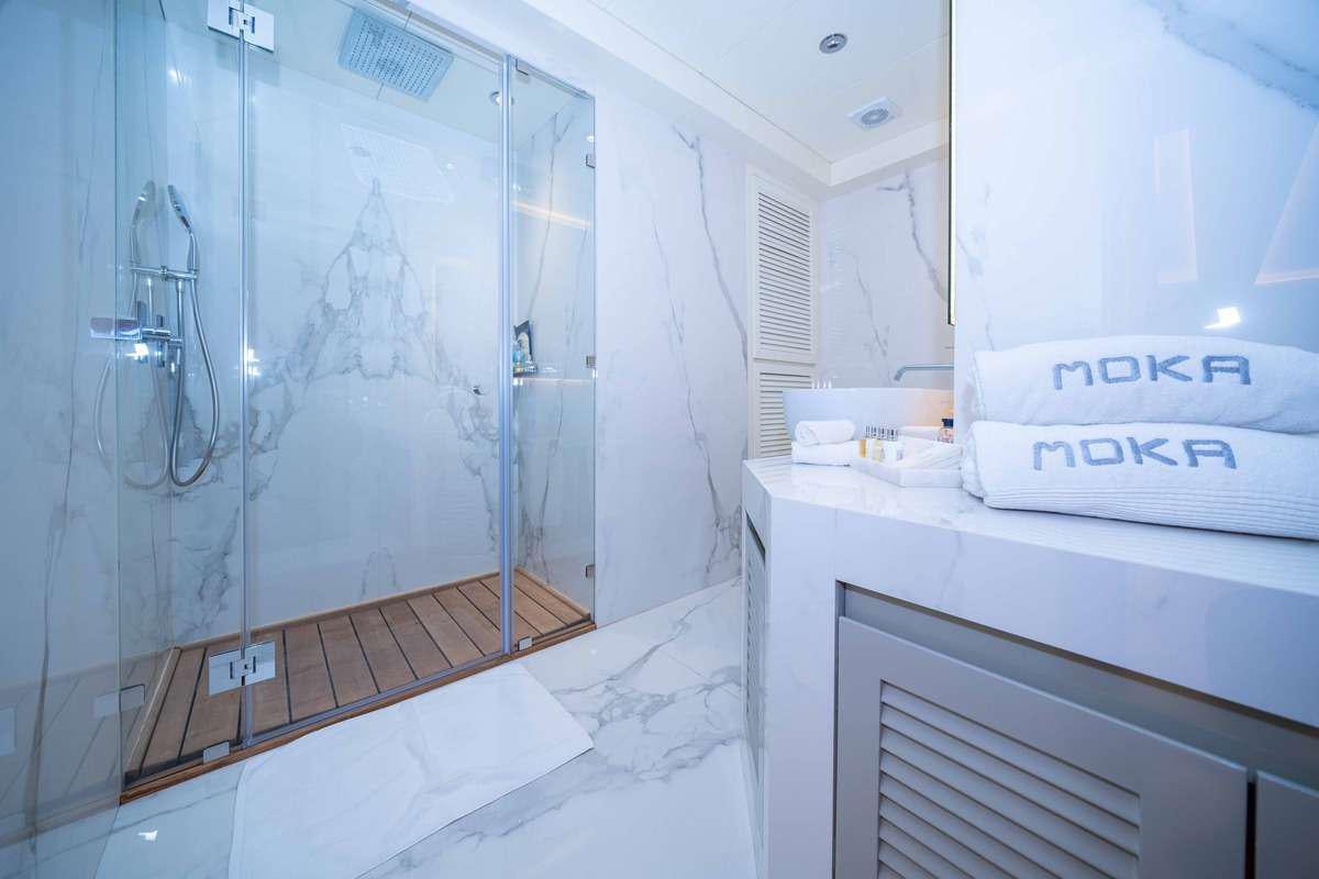 a bathroom with a glass shower aboard MOKA Yacht for Charter