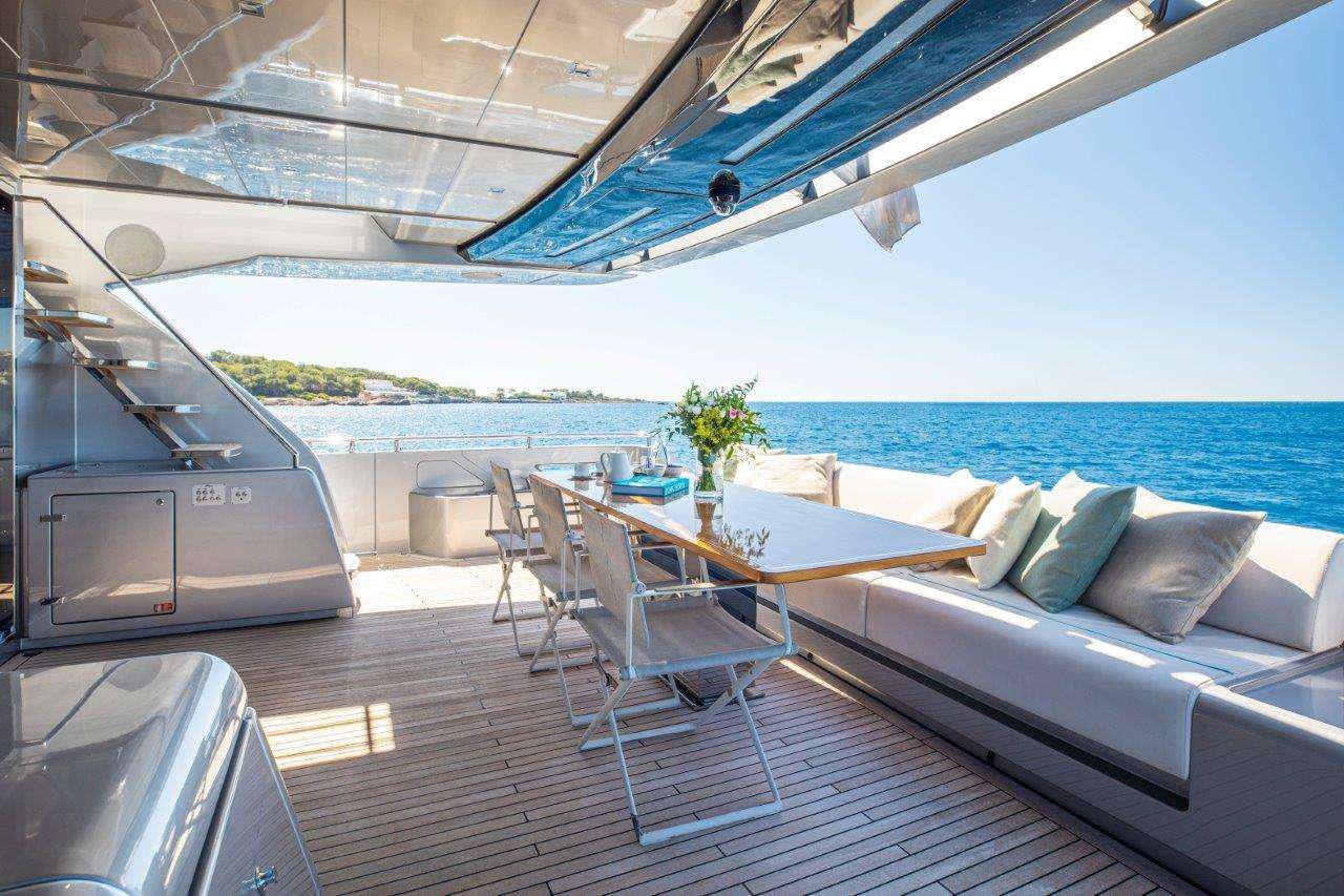 a deck with a table and chairs aboard NO STRESS 888 Yacht for Charter