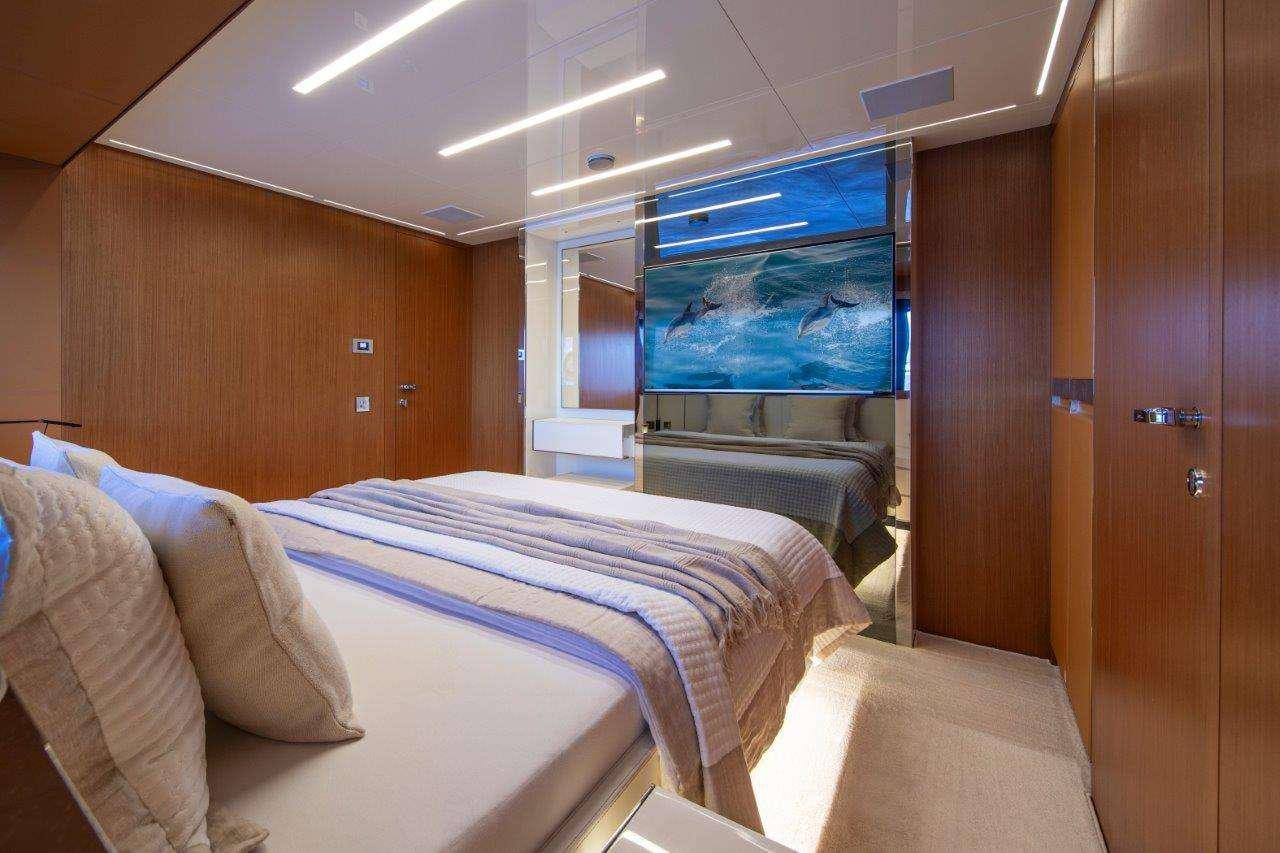 a room with a bed and a tv aboard NO STRESS 888 Yacht for Charter