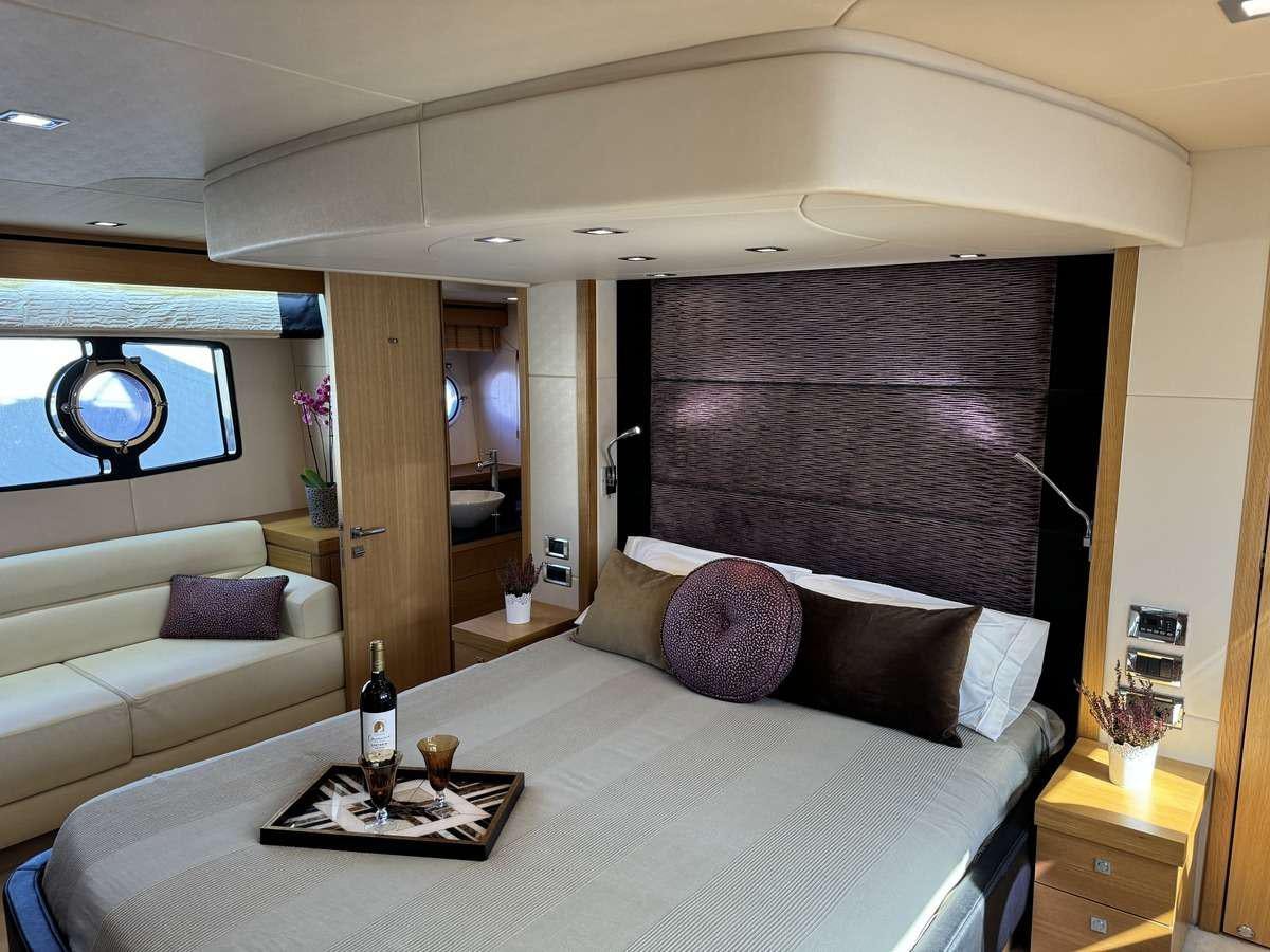 a bed with a couch and a window aboard POLPO Yacht for Charter