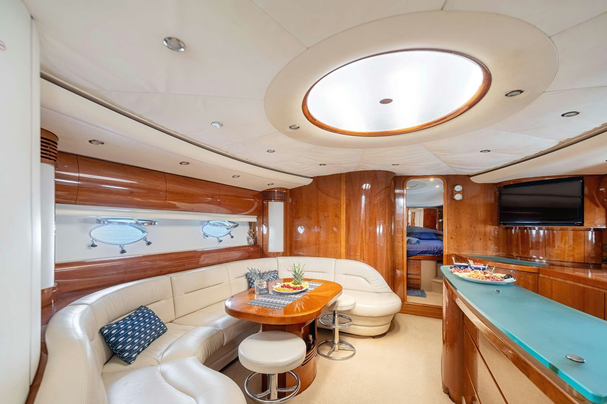 a room with a table and couch aboard EVENIA Yacht for Charter