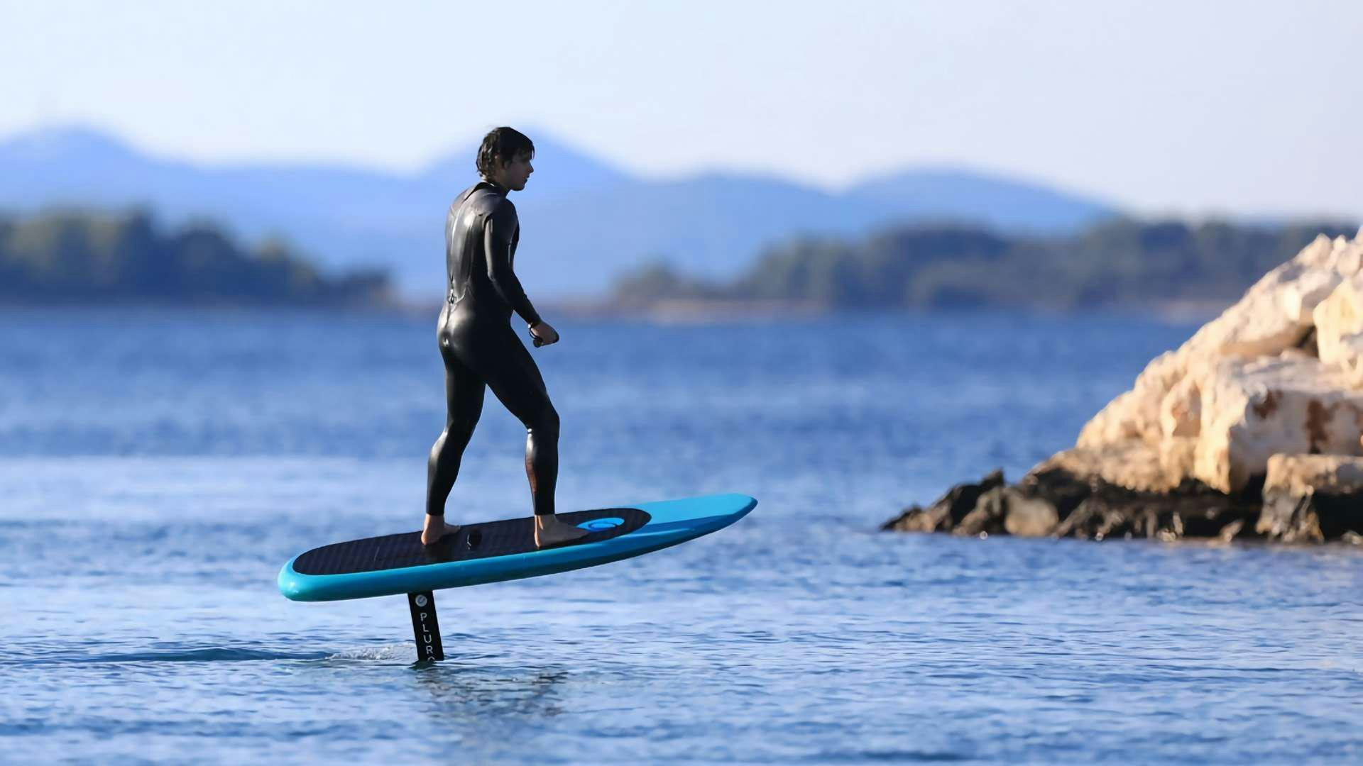 a man on a surfboard in the water aboard APOLLO Yacht for Charter