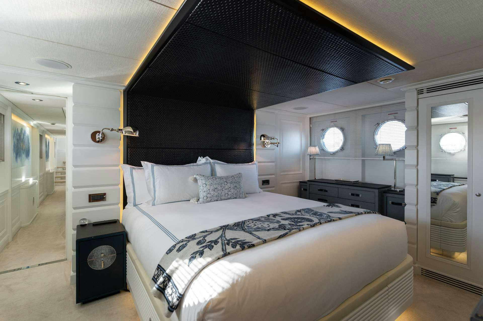 a room with a bed and a television aboard WONDERLAND Yacht for Charter
