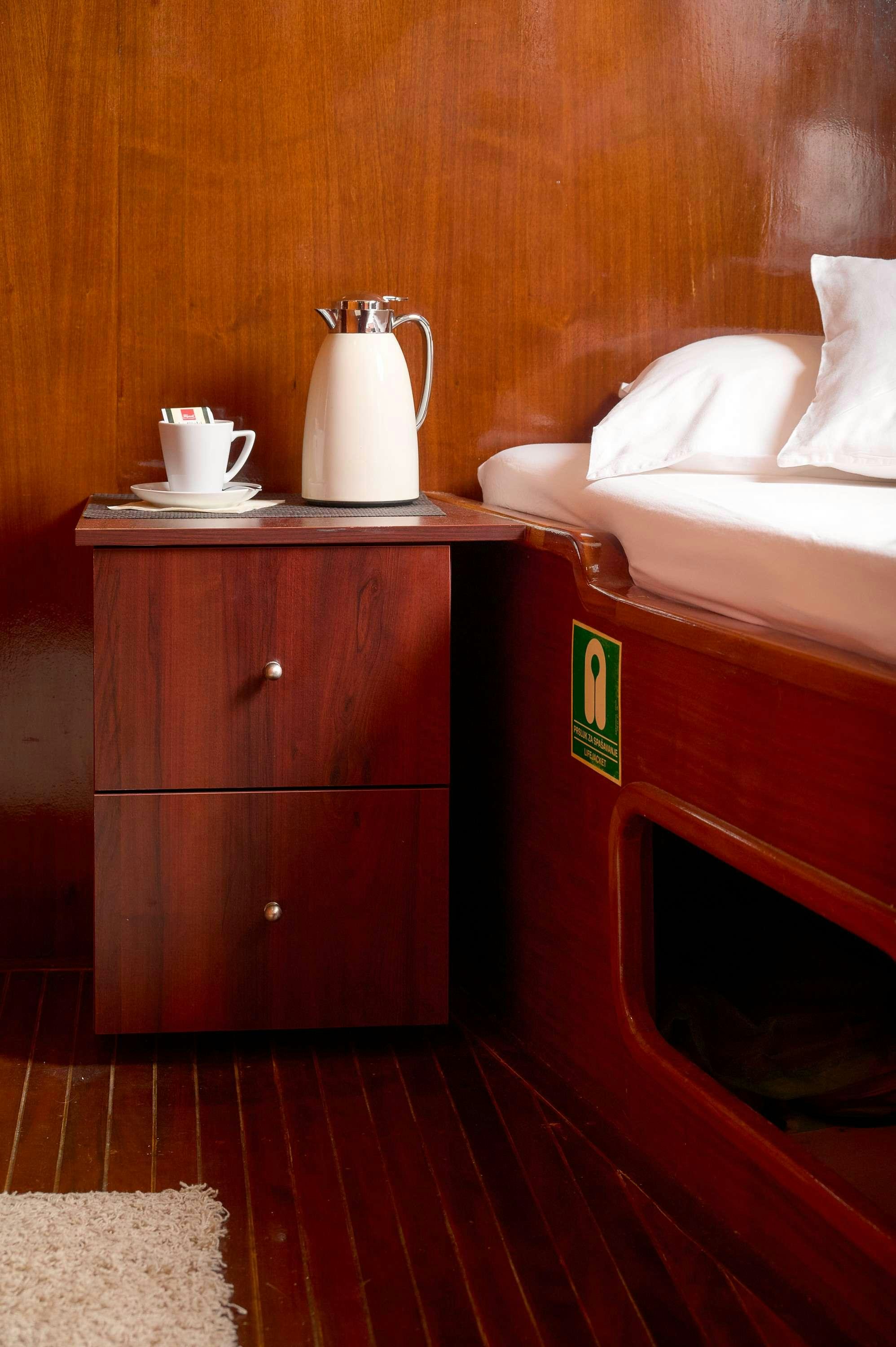 a room with a bed and a table aboard AGORA Yacht for Charter