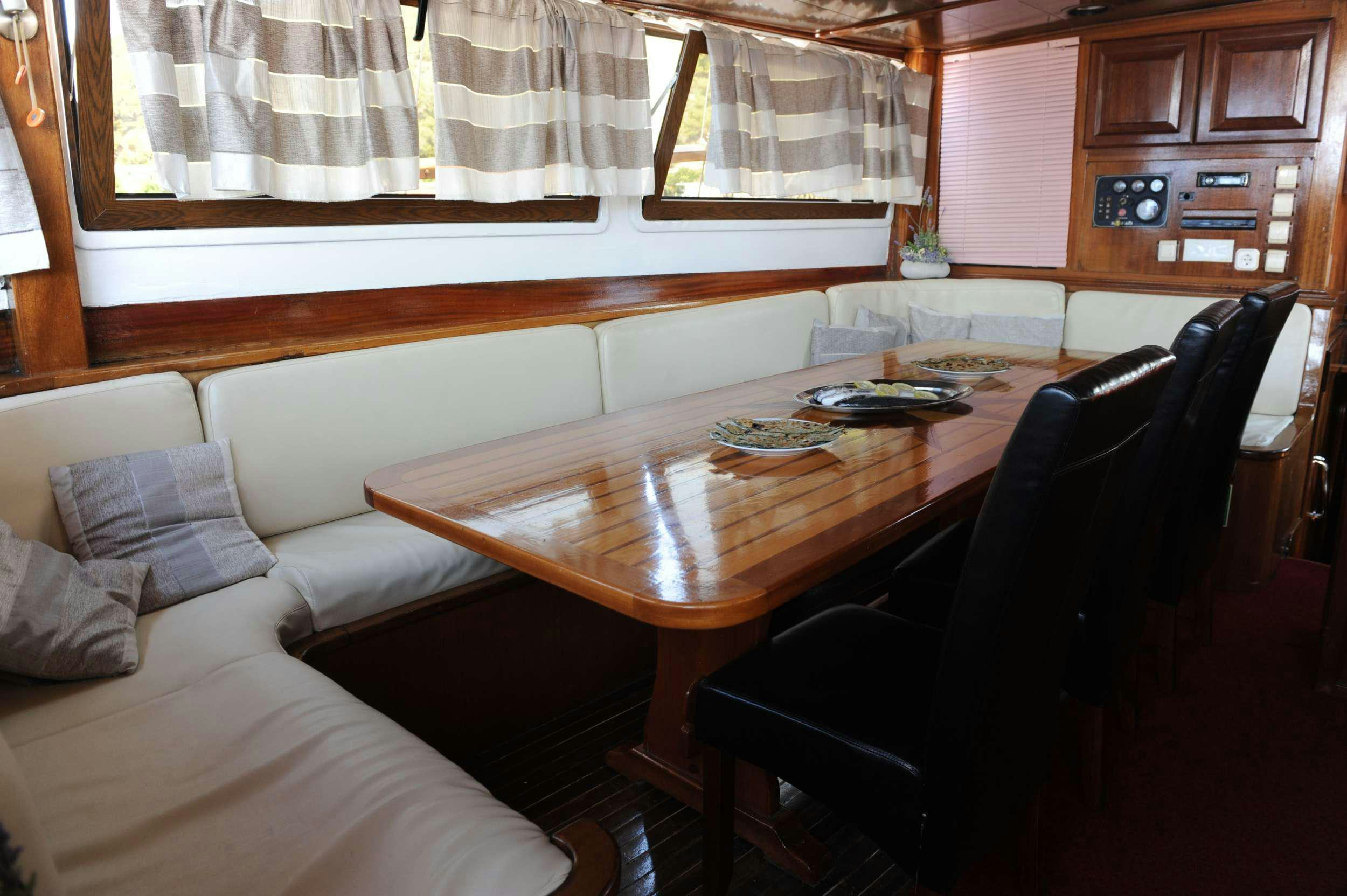 a living room with a table and couch aboard AGORA Yacht for Charter